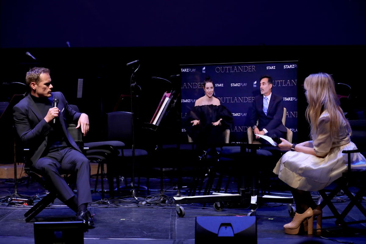 Sam Heughan, Caitriona Balfe via video link and Edith Bowman on stage during the panel discussion at the "Outlander" Season six premiere at The Royal Festival Hall on February 24, 2022 in London, England