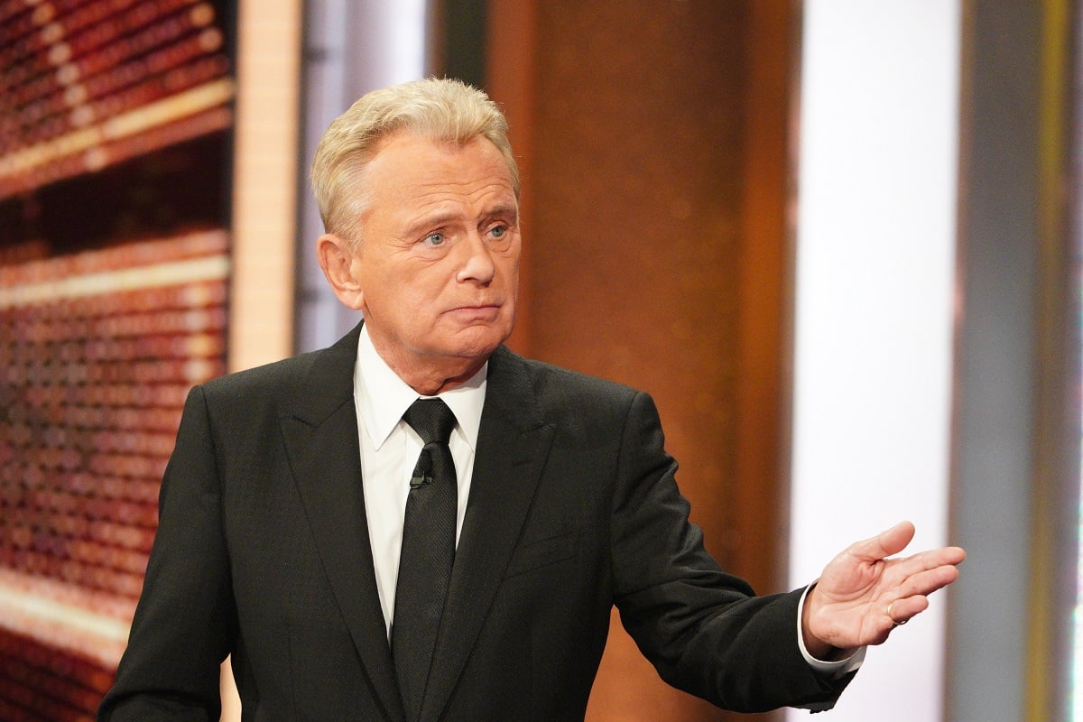 'Wheel of Fortune' host Pat Sajak wearing a tuxedo and standing on set of the game show.