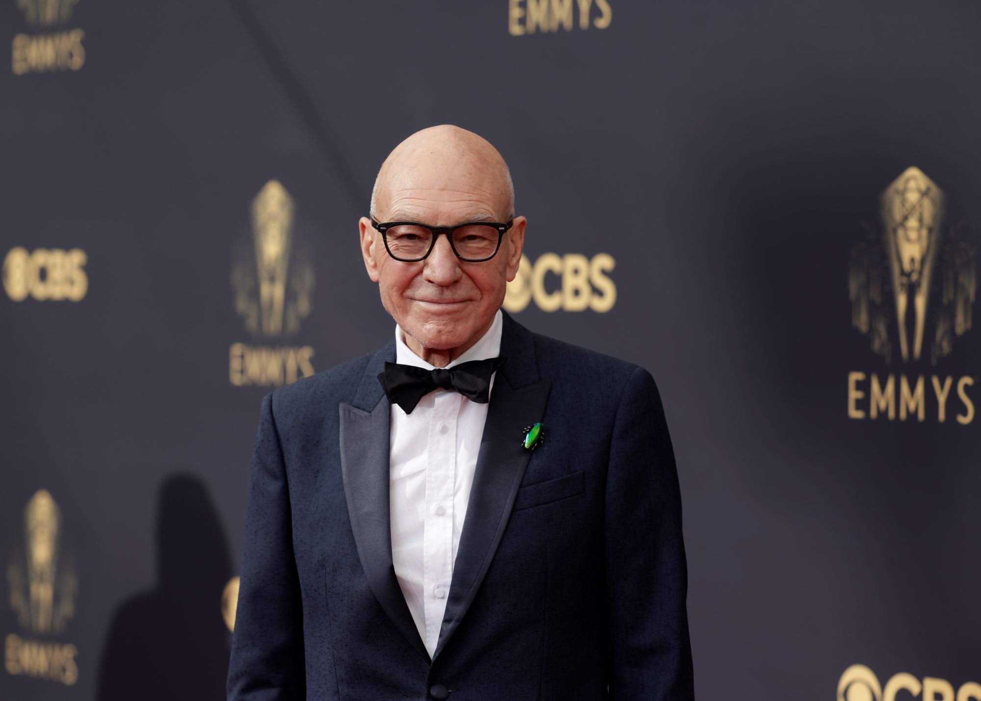 Patrick Stewart, who might play a member of the Illuminati in 'Doctor Strange 2,' wears black-framed glasses and a black suit over a white button-up shirt and black bow tie.