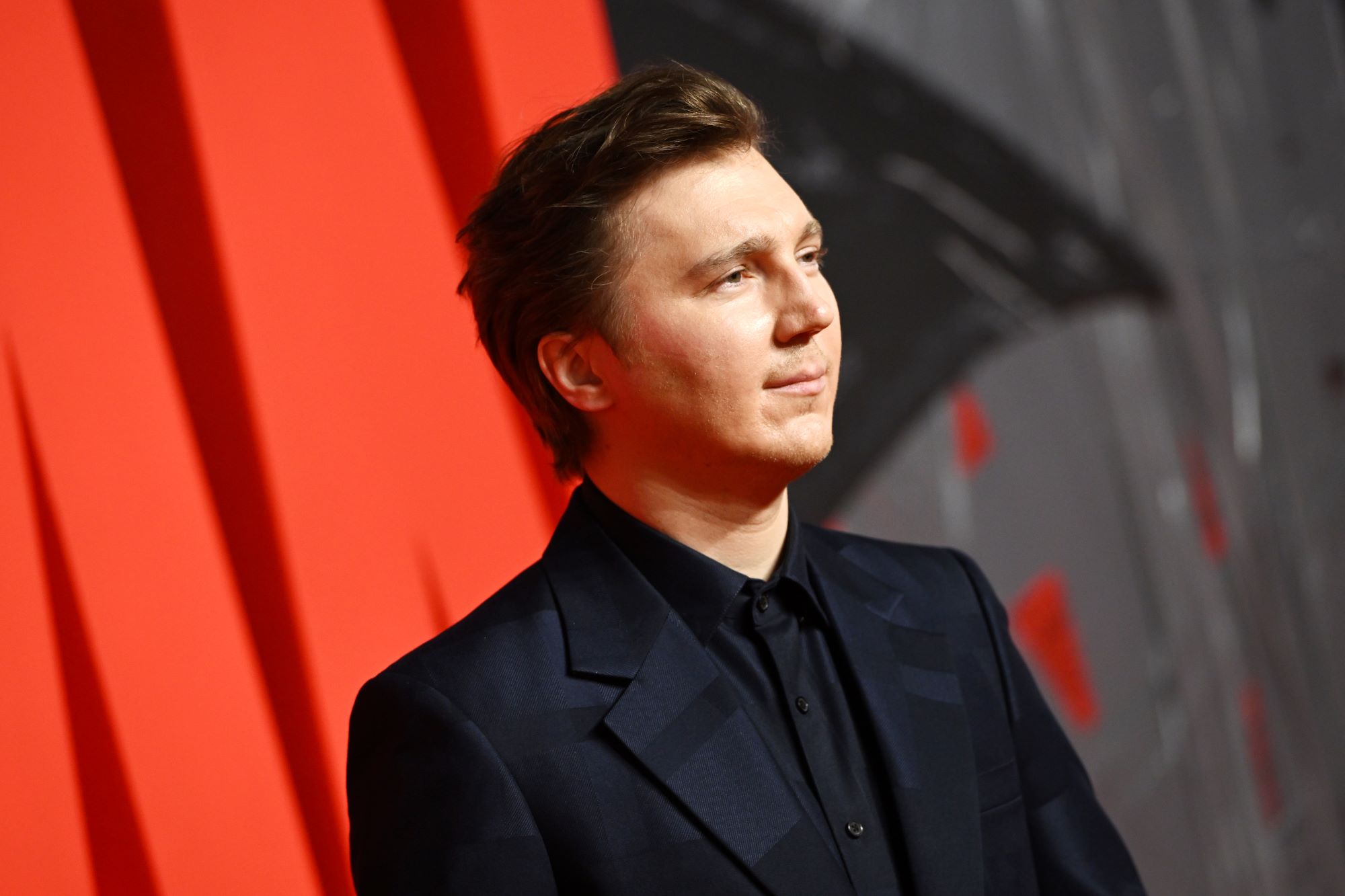 'The Batman' star Paul Dano, who plays the Riddler in the film, wears a black suit over a black button-up shirt.