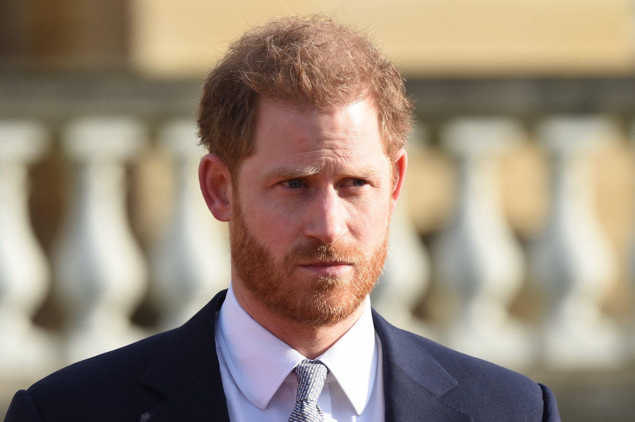 Prince Harry looking on while wearing a suit, close up