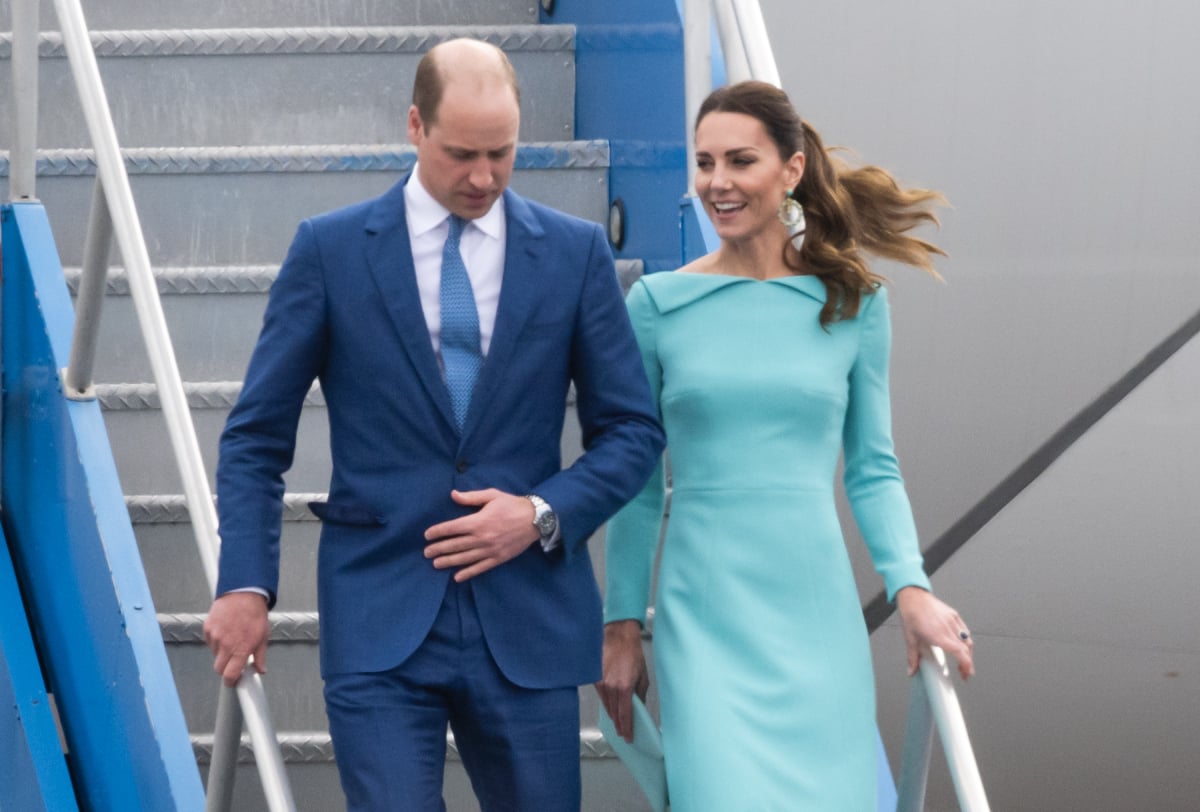 Kate Middleton wearing bright turquoise blue dress and Prince William in a blue suit and tie arrive for their royal tour of the Caribbean.