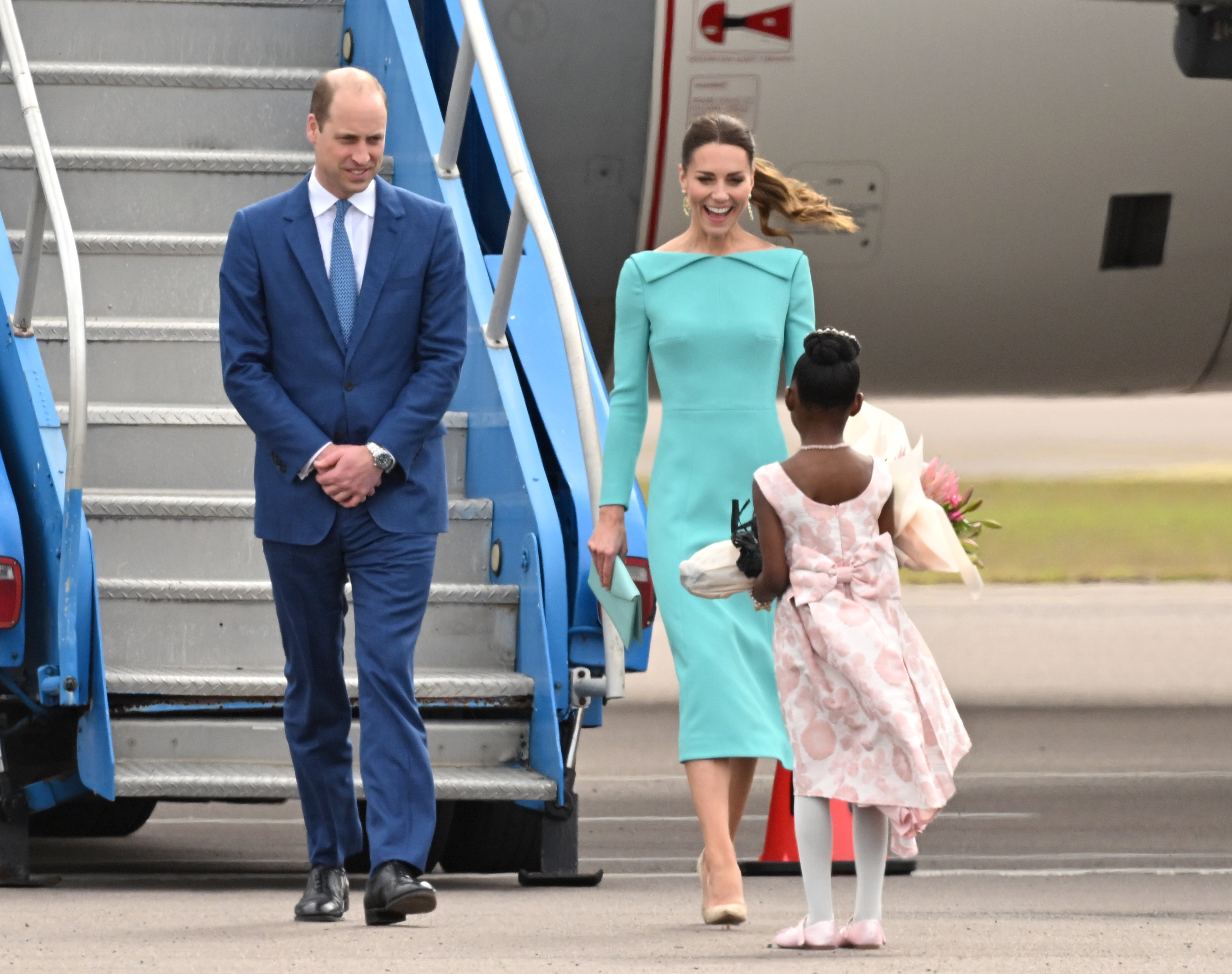 Prince William and Kate Middleton are greeted in the Bahamas at at Lynden Pindling International Airport by Aniah Moss, who gave the duchess flowers