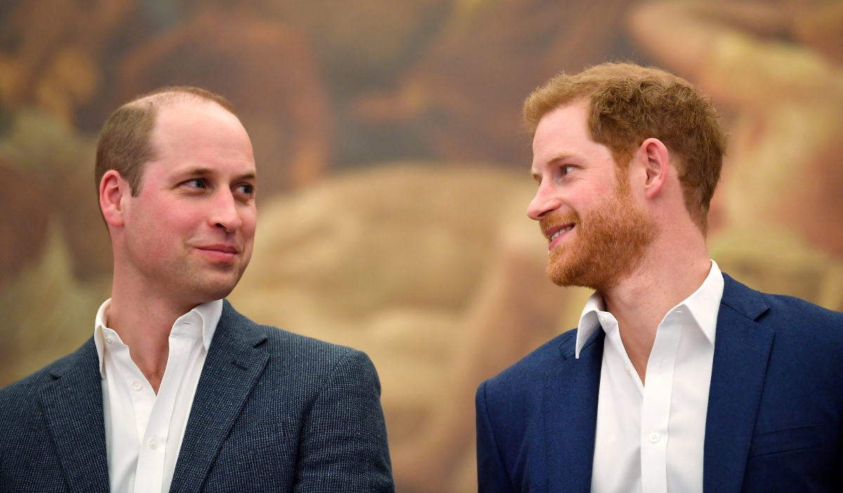Prince William, Duke of Cambridge and Prince Harry wearing white shirts and suit jackets look at each other as they attend the opening of the Greenhouse Sports Centre on April 26, 2018 in London, United Kingdom