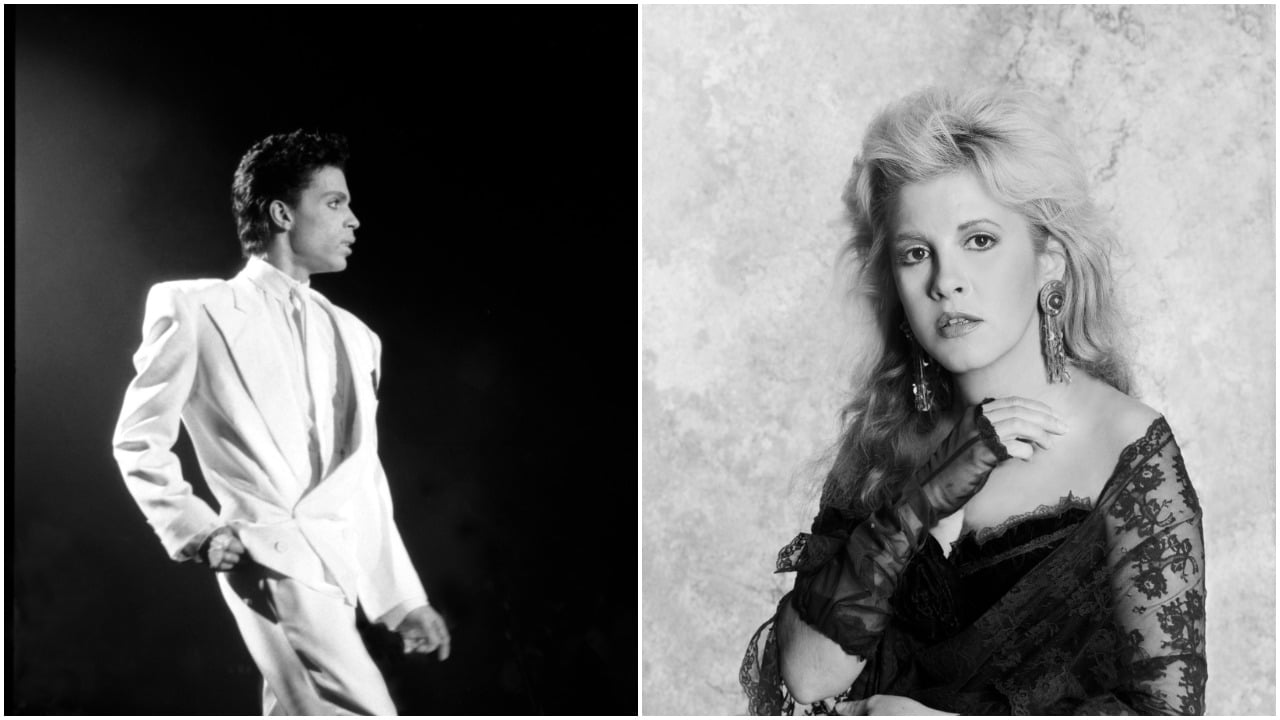 A black and white photo of Prince wearing an all-white suit. Stevie Nicks wears a lace shirt and lace fingerless gloves.