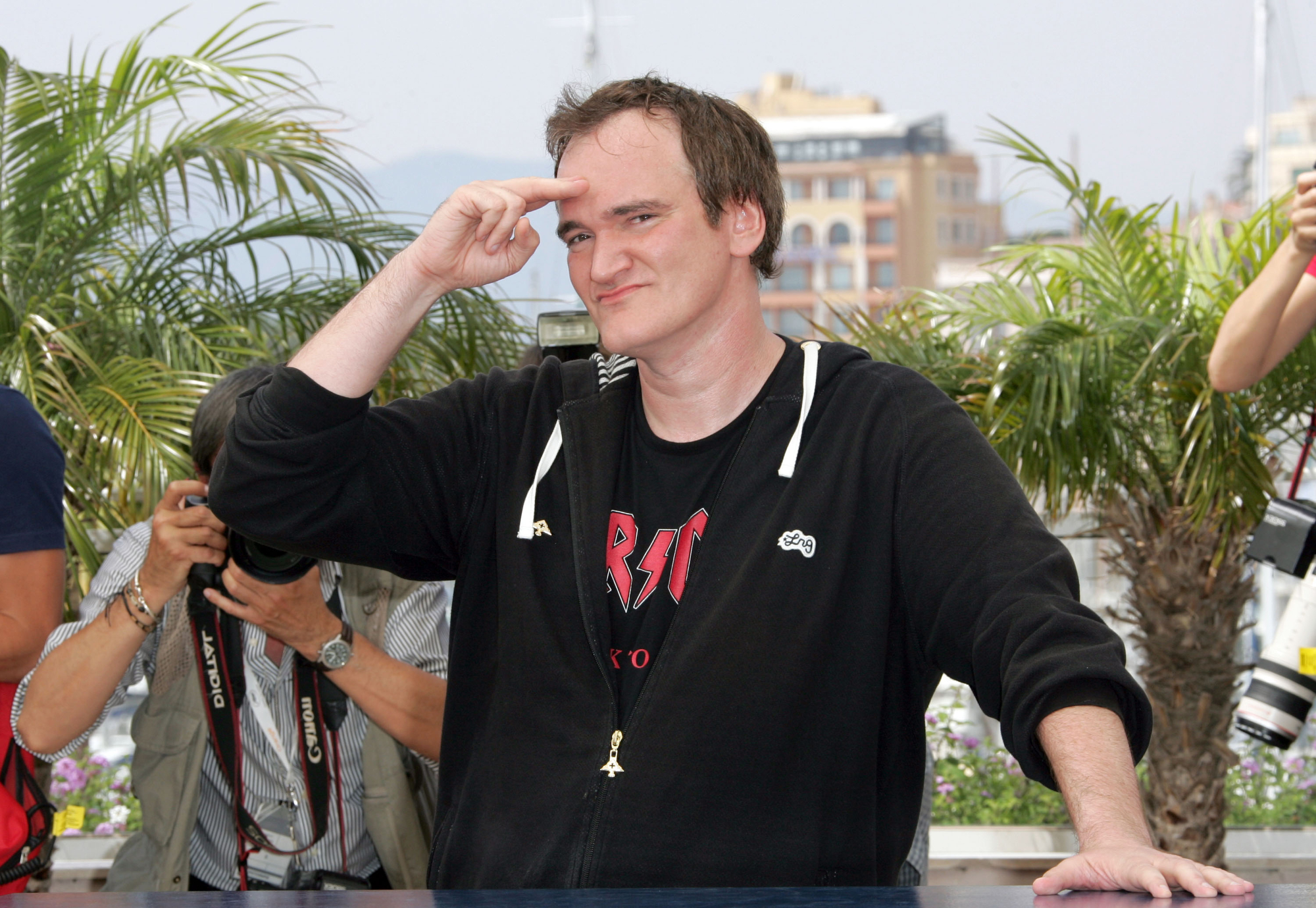 Quentin Tarantino promoting 'Death Proof' movie wearing a hoodie saluting the camera