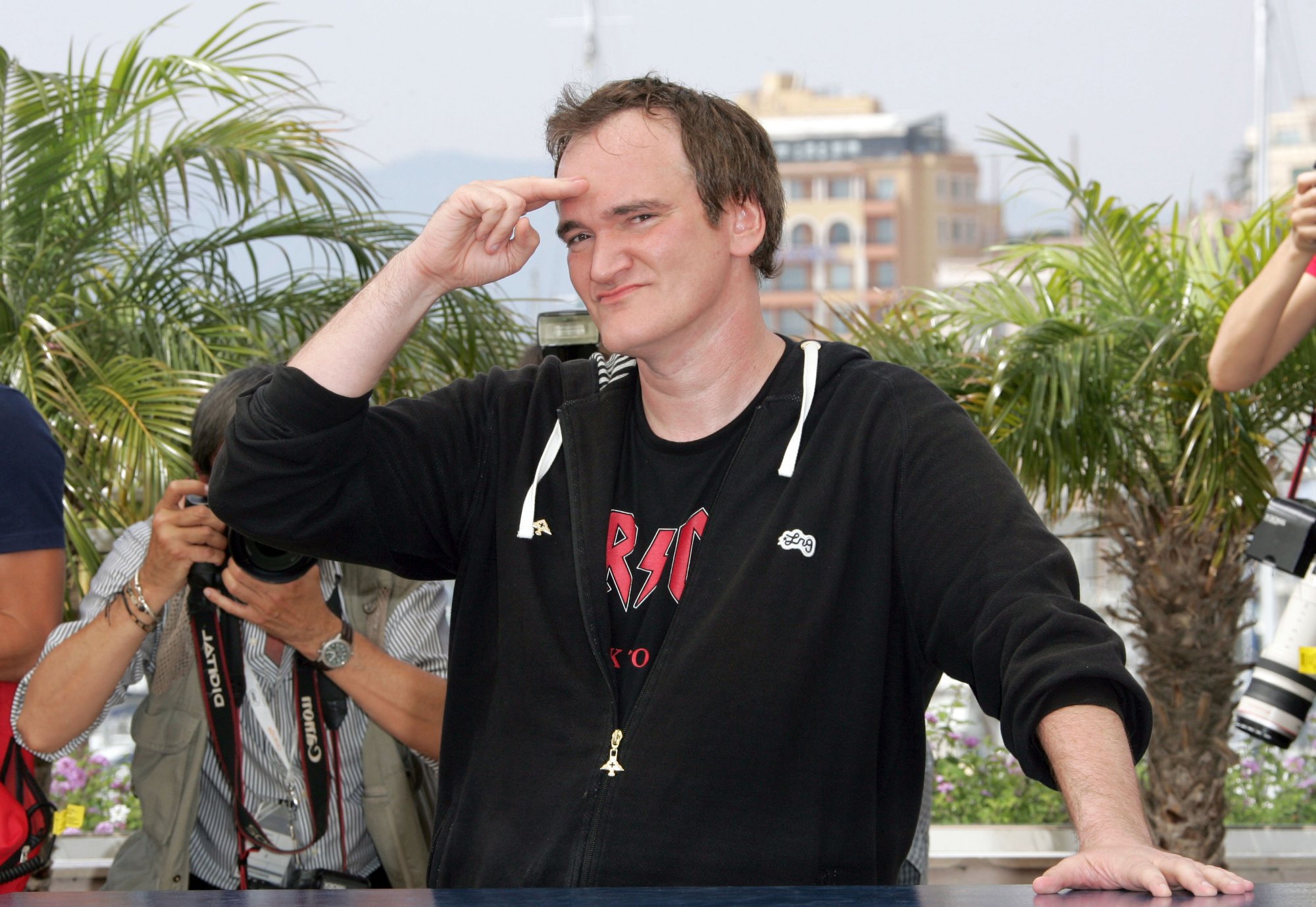Quentin Tarantino promoting 'Death Proof' movie wearing a hoodie saluting the camera
