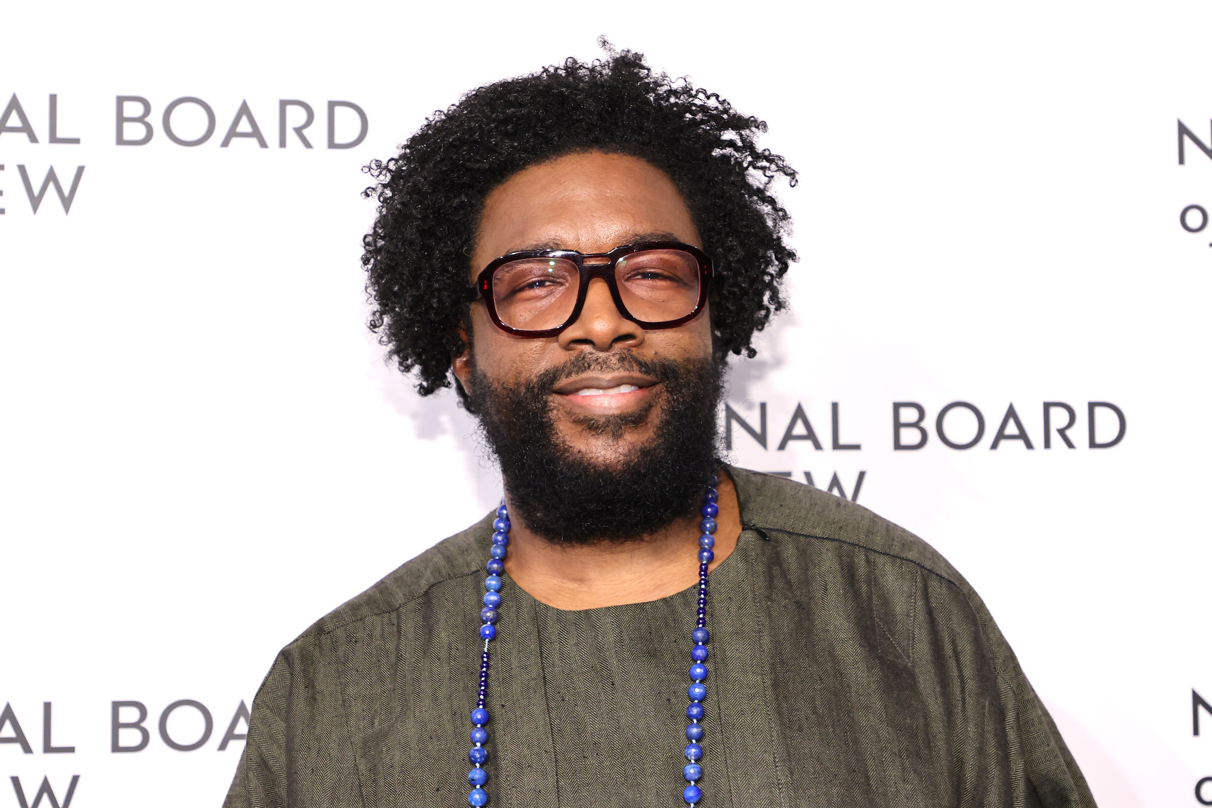 Ahmir "Questlove" Thompson smiling on a white background