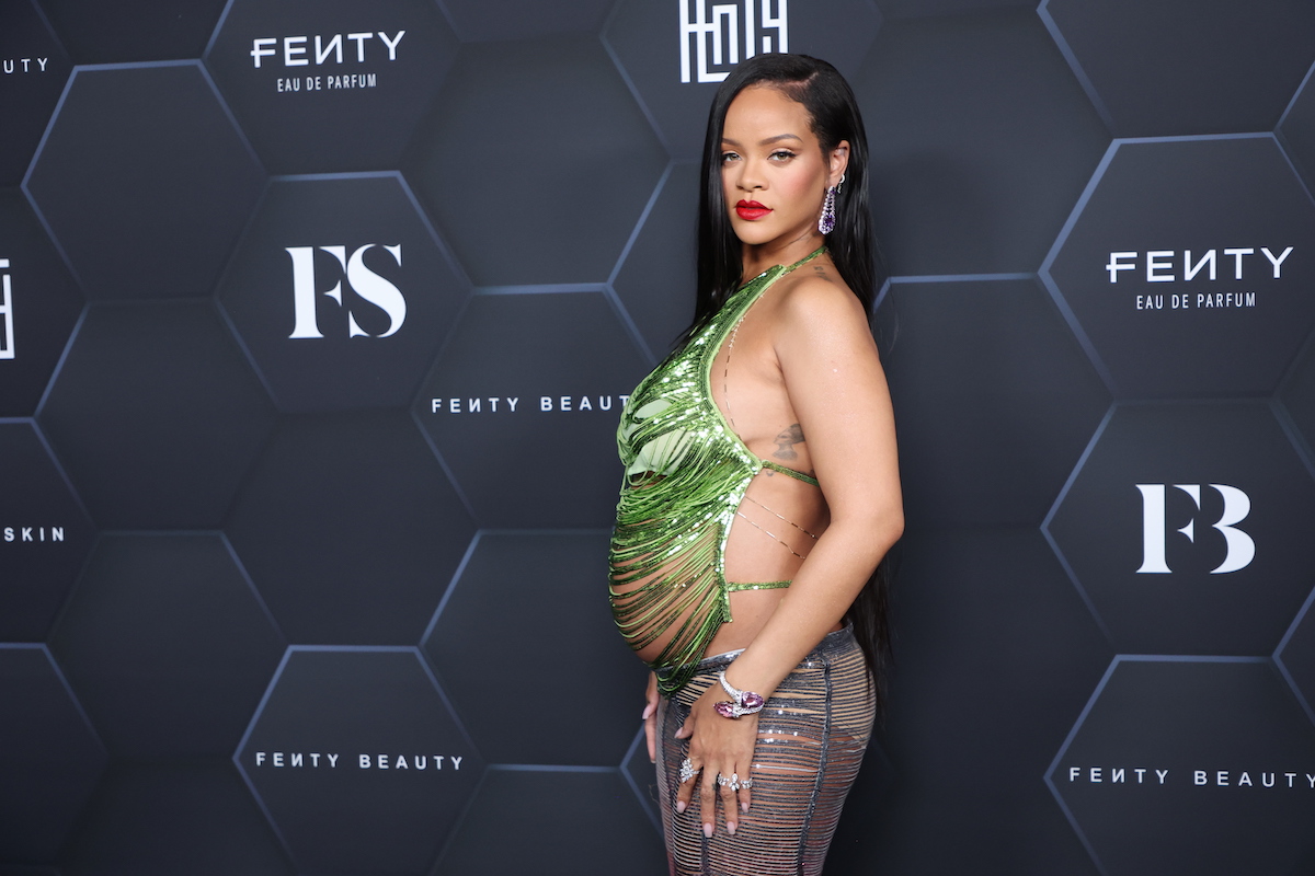 Rihanna poses in a green dress at an event.
