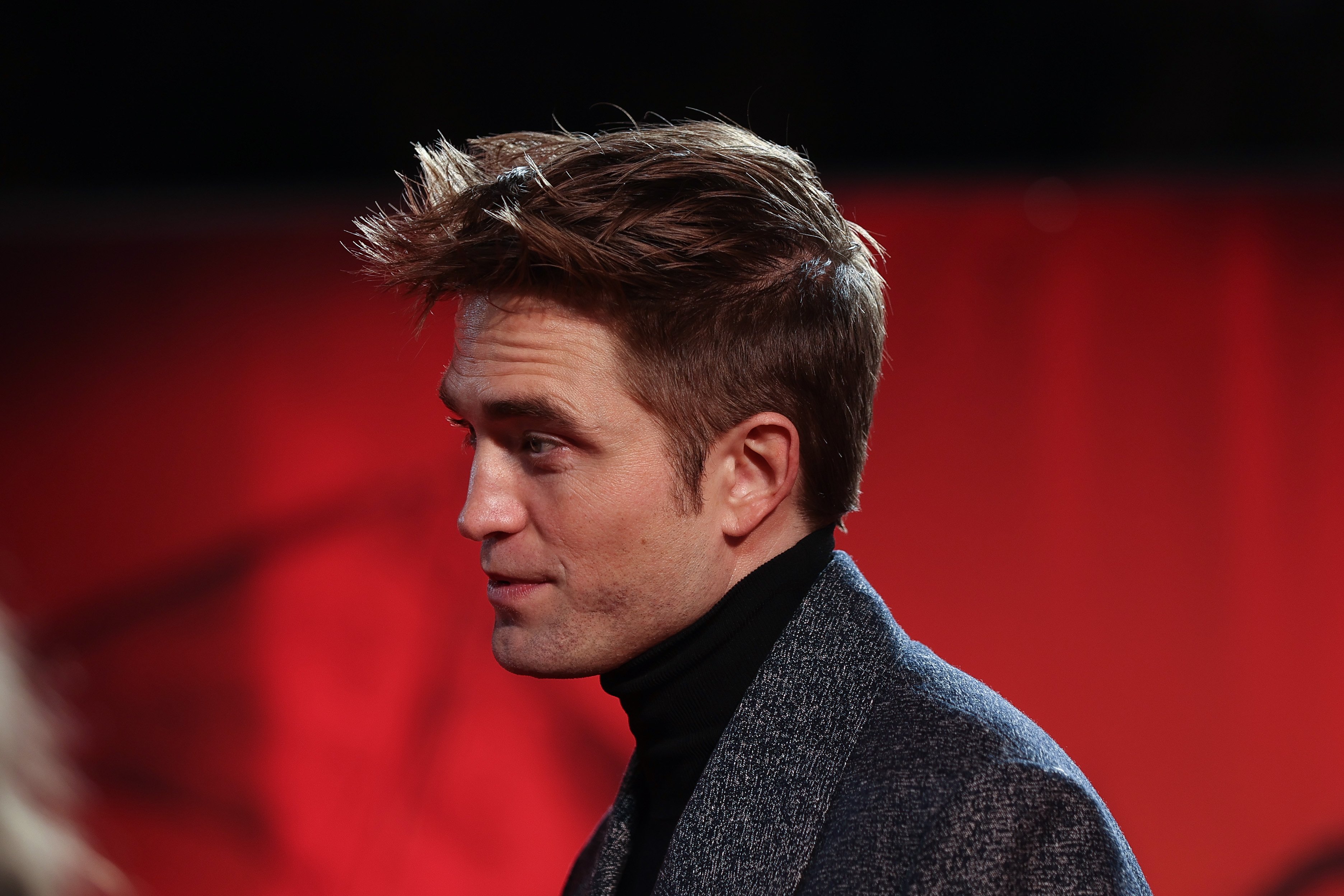 'The Batman' star Robert Pattinson wears a gray coat over a black turtleneck.