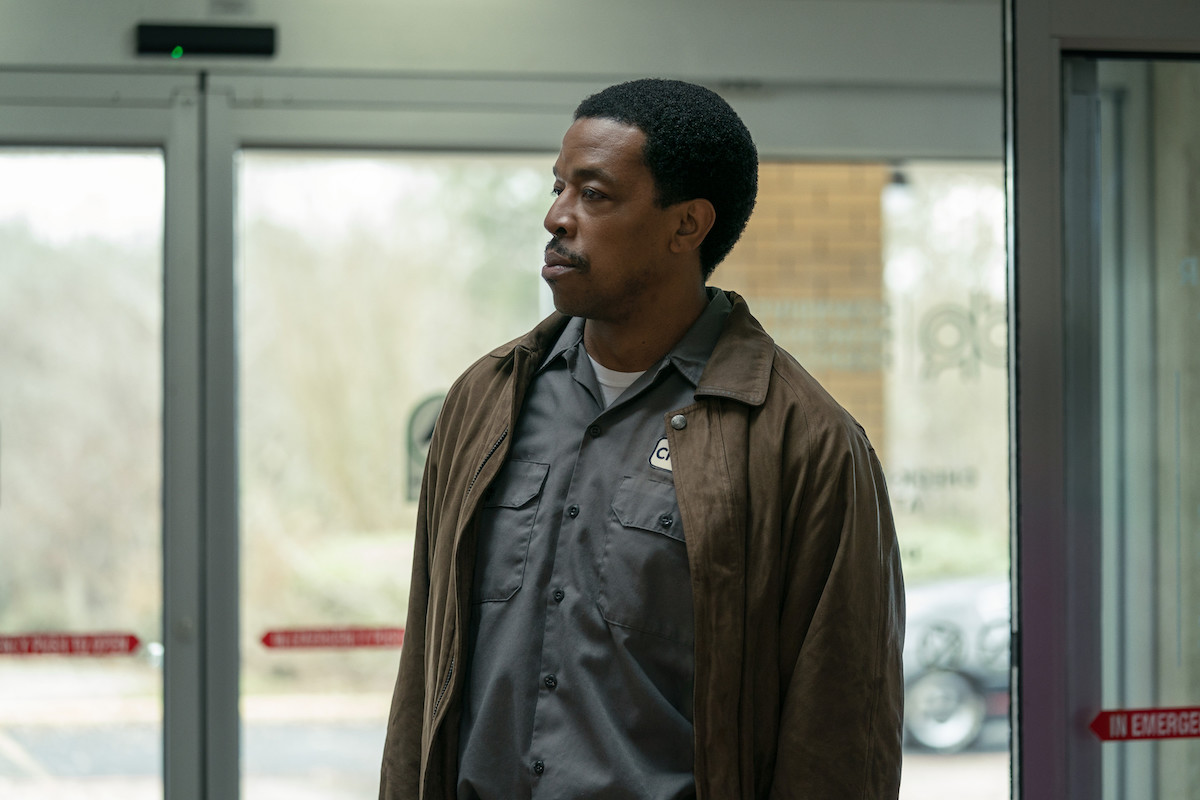 Russell Hornsby as Charles Flenory wearing a work jumpsuit and jacket while standing in the hospital waiting area in 'BMF'