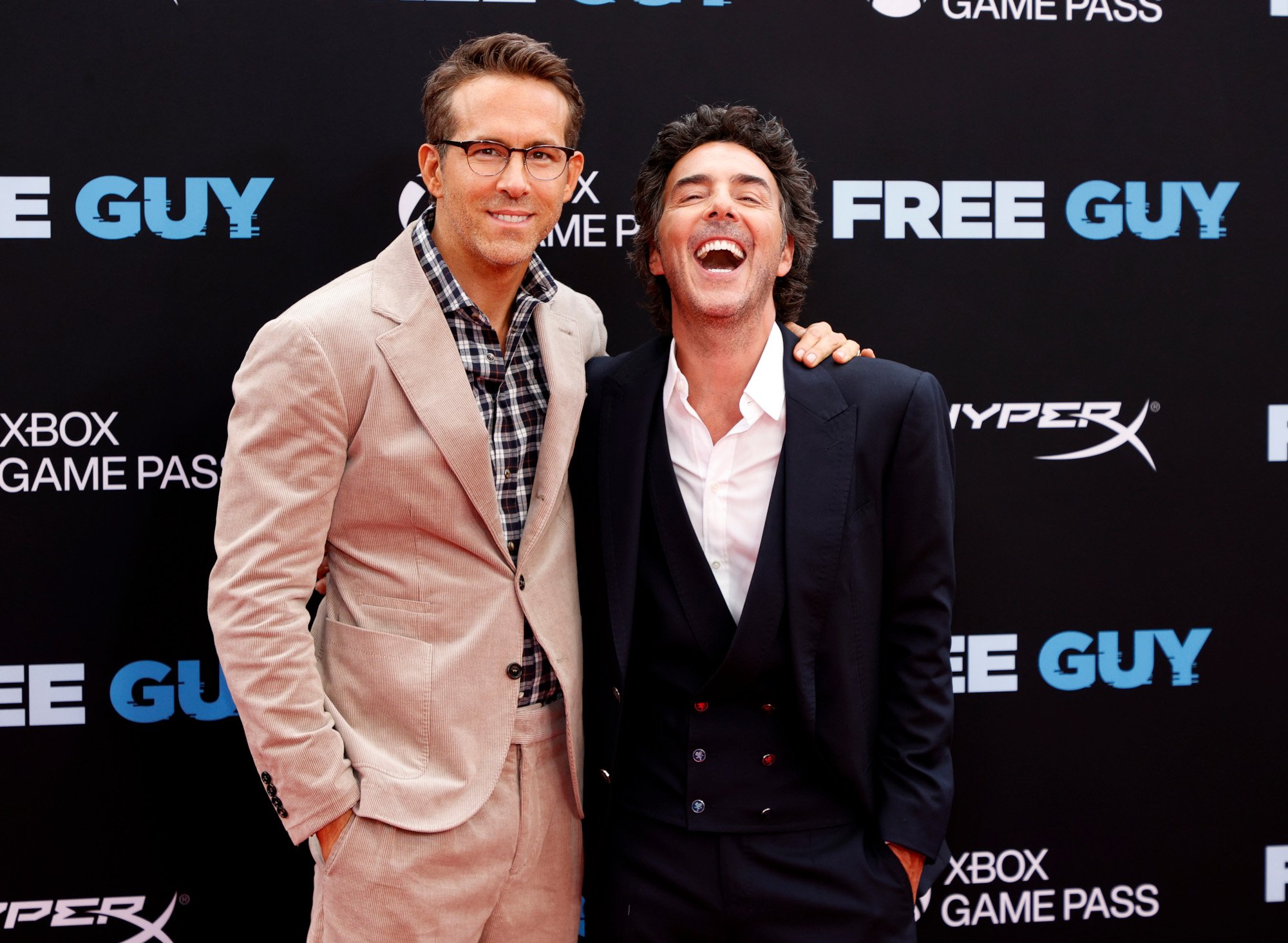 Ryan Reynolds and Shawn Levy at the premiere for Disney's 'Free Guy.' Reynolds has his arm around Levy, and Levy is laughing.