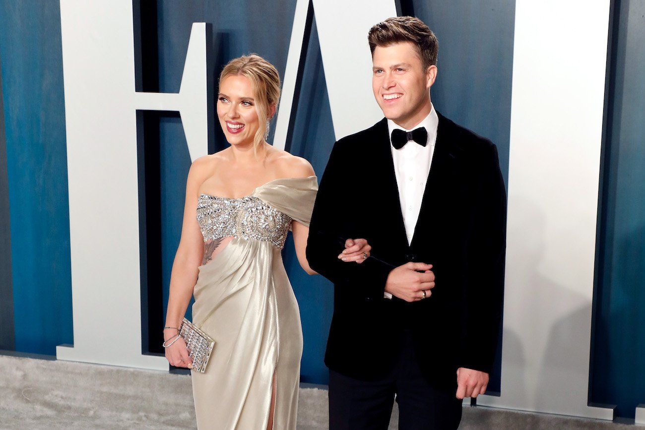 Scarlett Johansson wearing a dress and standing with Colin Jost, who is wearing a tuxedo