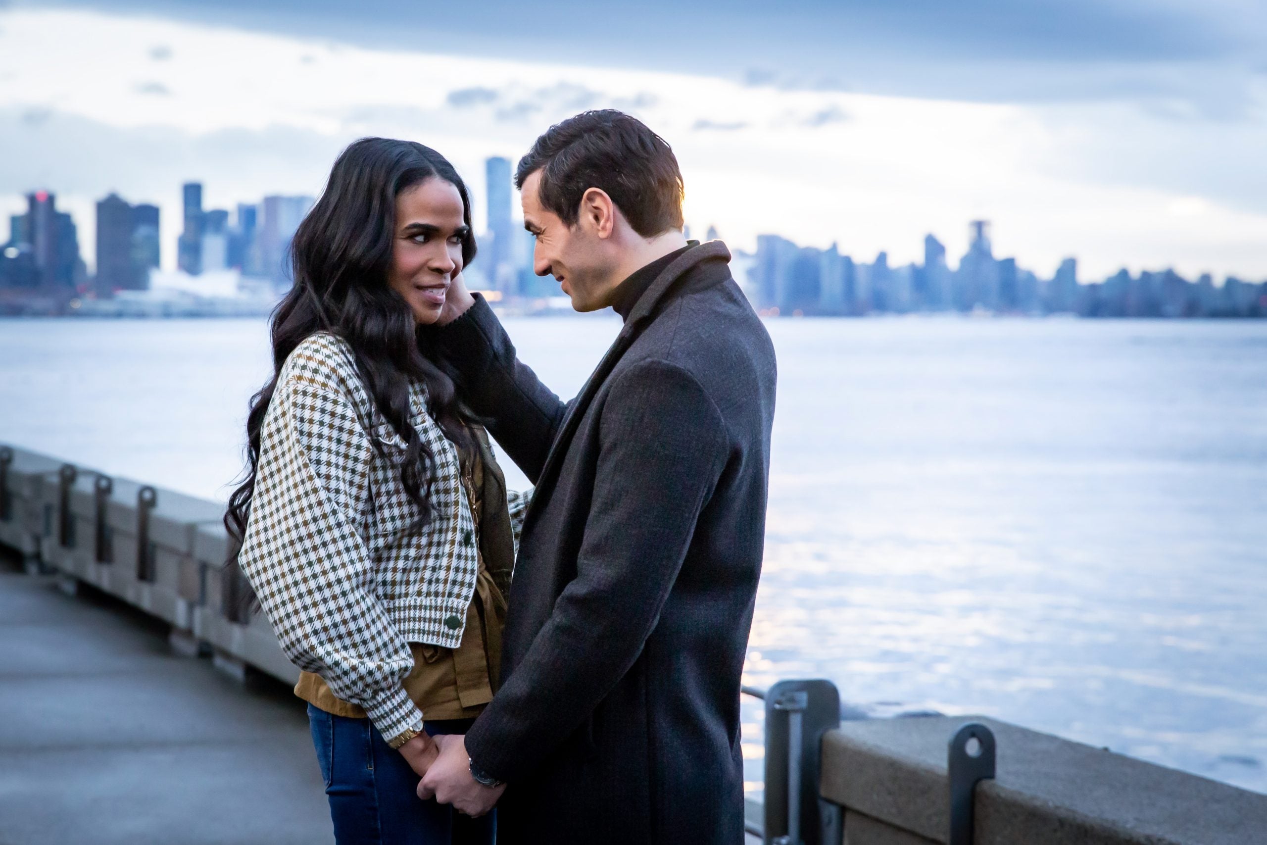 Antonio Cupo touching Michelle Williams cheek as they stand in front of a city skyline in the Lifetime movie 'Wrath: A Seven Deadly Sins Story'