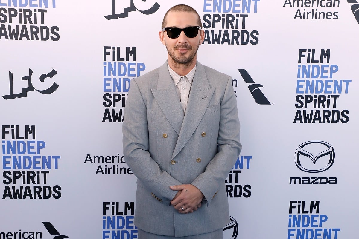 Shia LaBeouf posing in a gray suit.