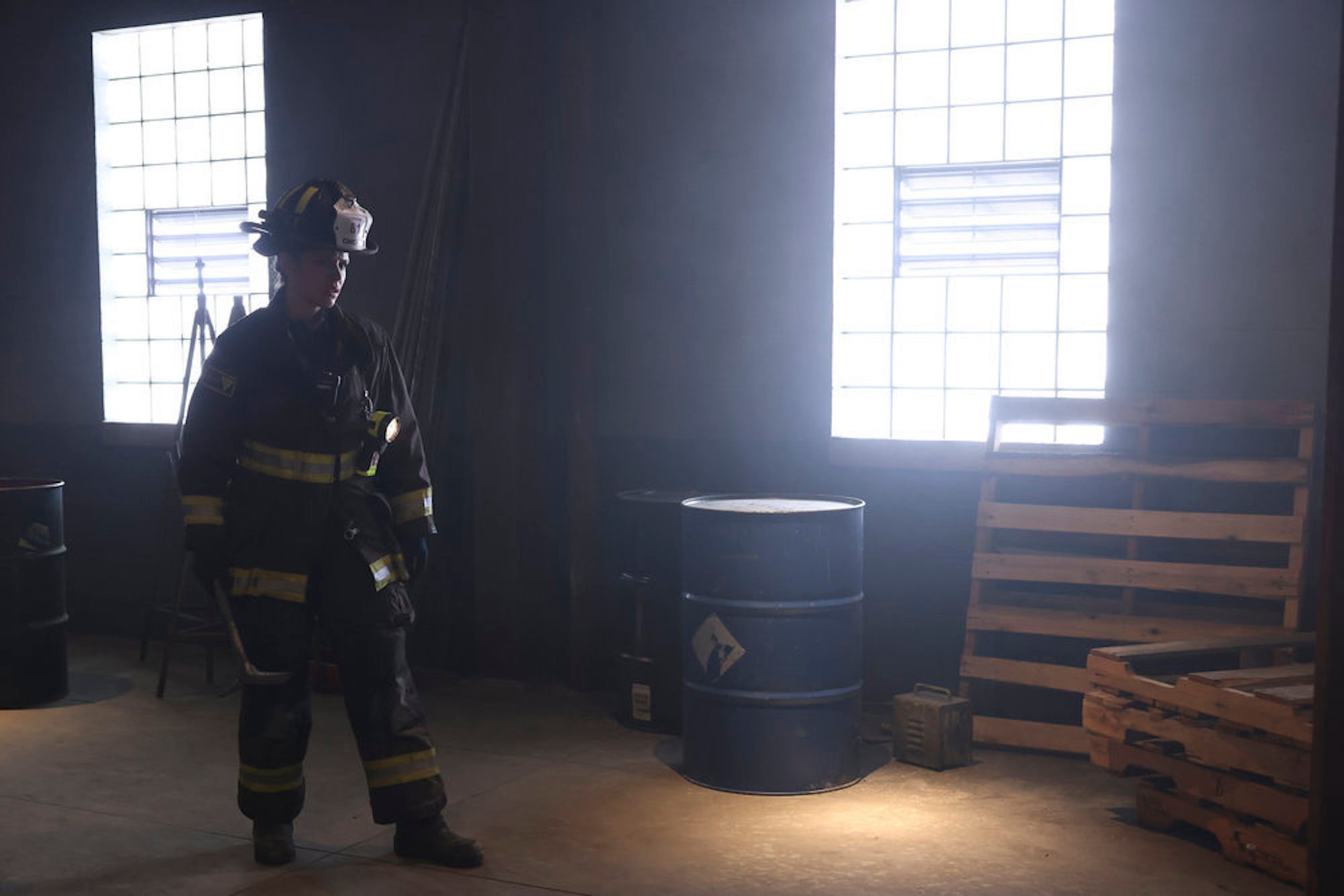 Miranda Rae Mayo as Stella Kidd in uniform in a dark, run-down building in 'Chicago Fire' Season 10 Episode 15