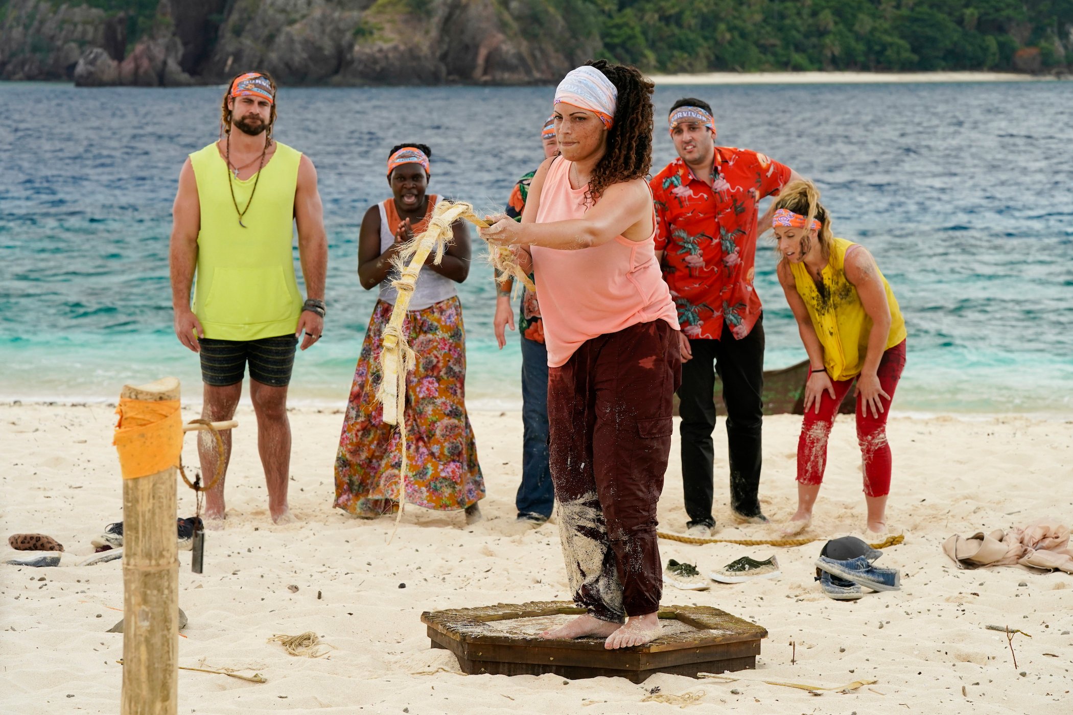 Marya Sherron in the front of her tribe holding a long stick during a challenge on the beach in 'Survivor' Season 42