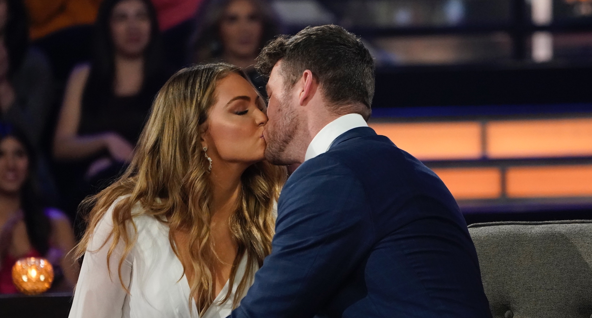 Susie Evans and Clayton Echard for 'The Bachelor' wearing white dress and blue suit kissing.