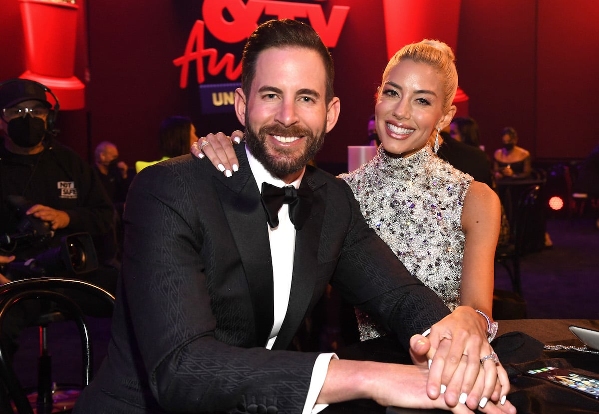 Tarek El Moussa and Heather Rae Young sit together at an event.