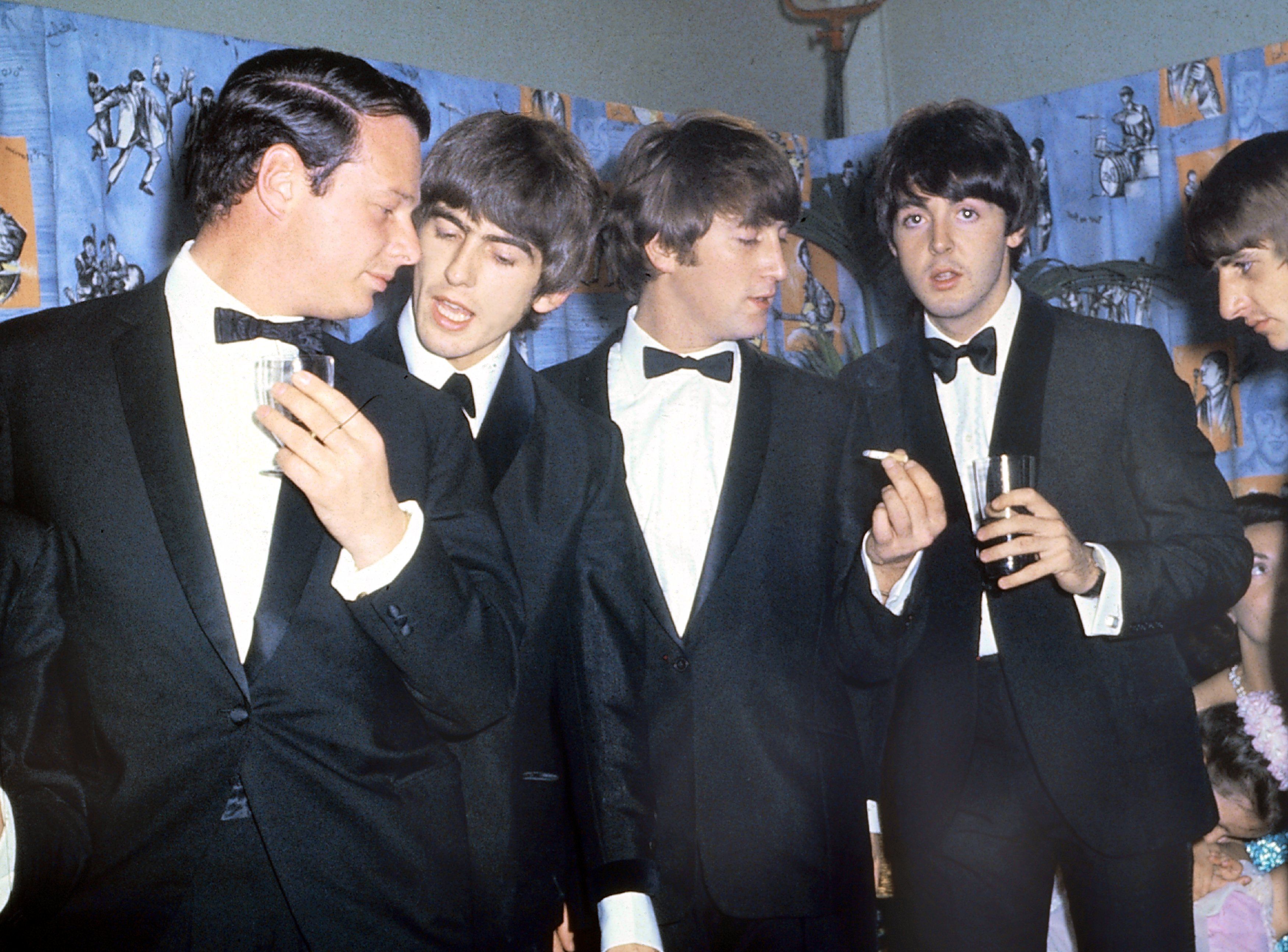 Portrait of The Beatles with their manager Brian Epstein at a reception between 1964 and 1966