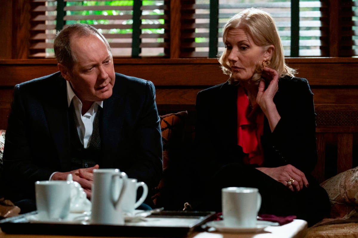 James Spader as Raymond "Red" Reddington, Joely Richardson as Cassandra Bianchi in The Blacklist Season 9. Cassandra and Red sit on the couch with coffee cups in front of them.