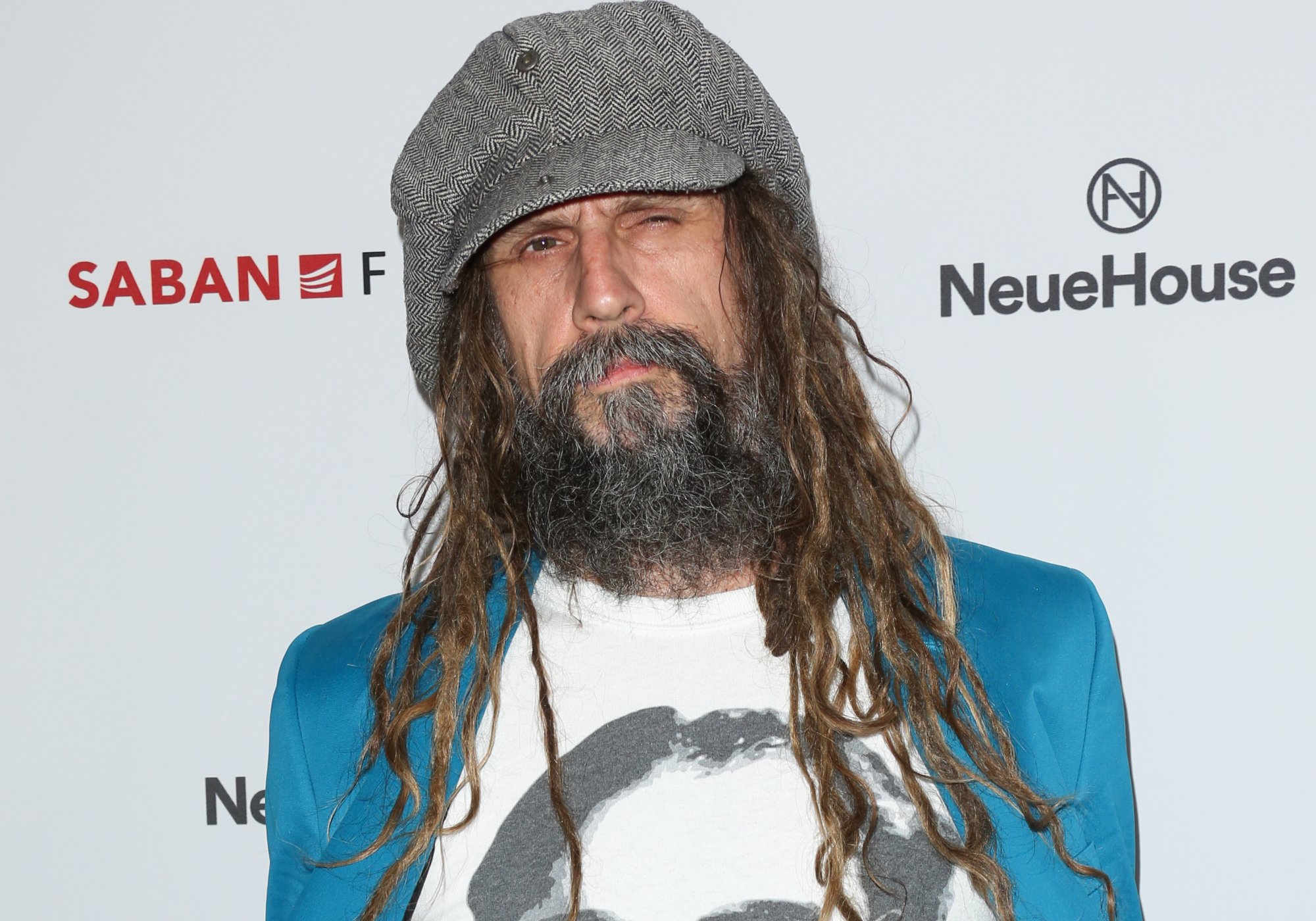 'The Munsters' filmmaker Rob Zombie standing in front of white step and repeat