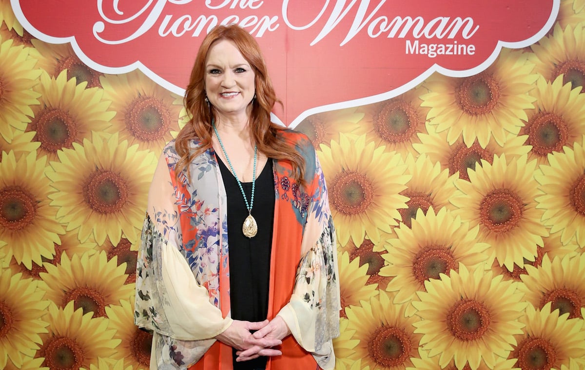 Pioneer Woman Ree Drummond smiles standing in front a sunflower wall