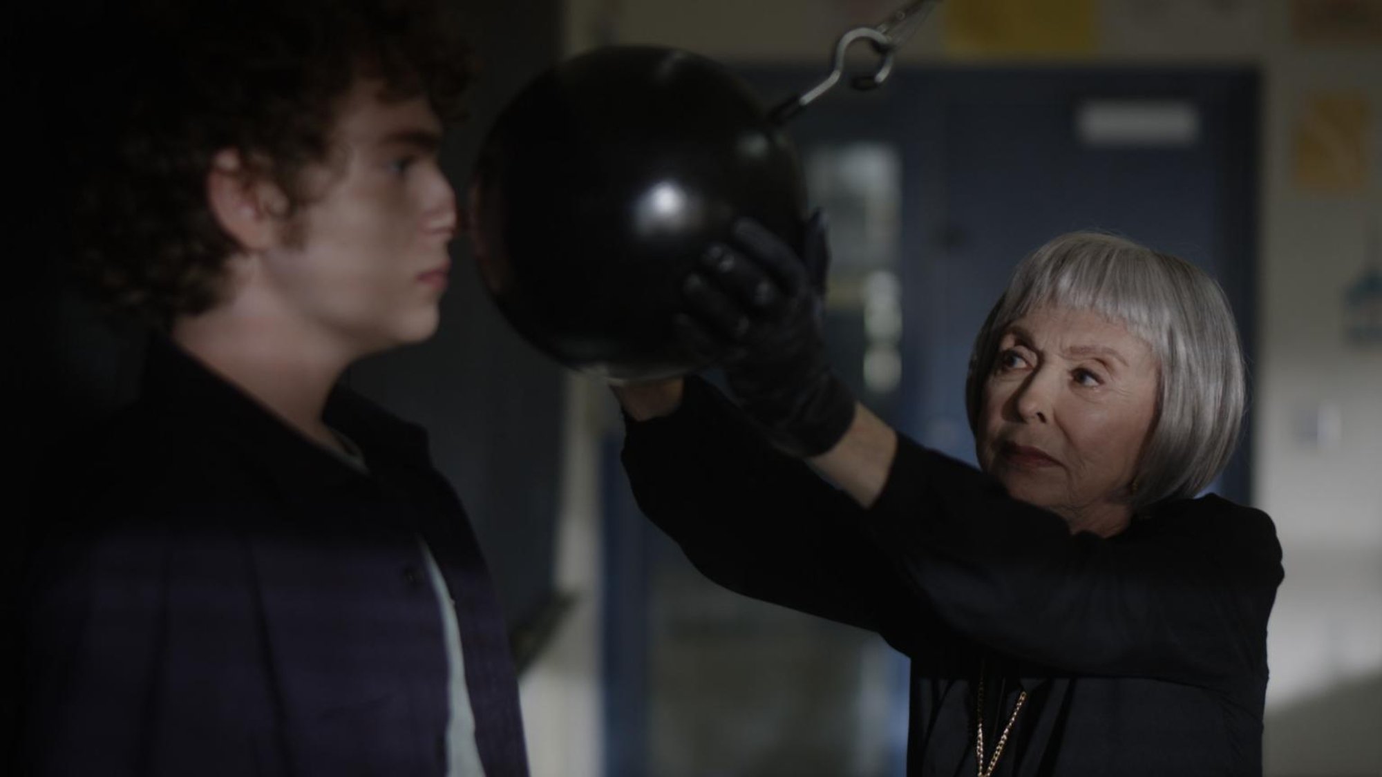 'The Prank' Connor Kalopsis as Ben and Rita Moreno as Mrs. Wheeler wearing black gloves and a big, black ball on a swinging pendulum in front of his face
