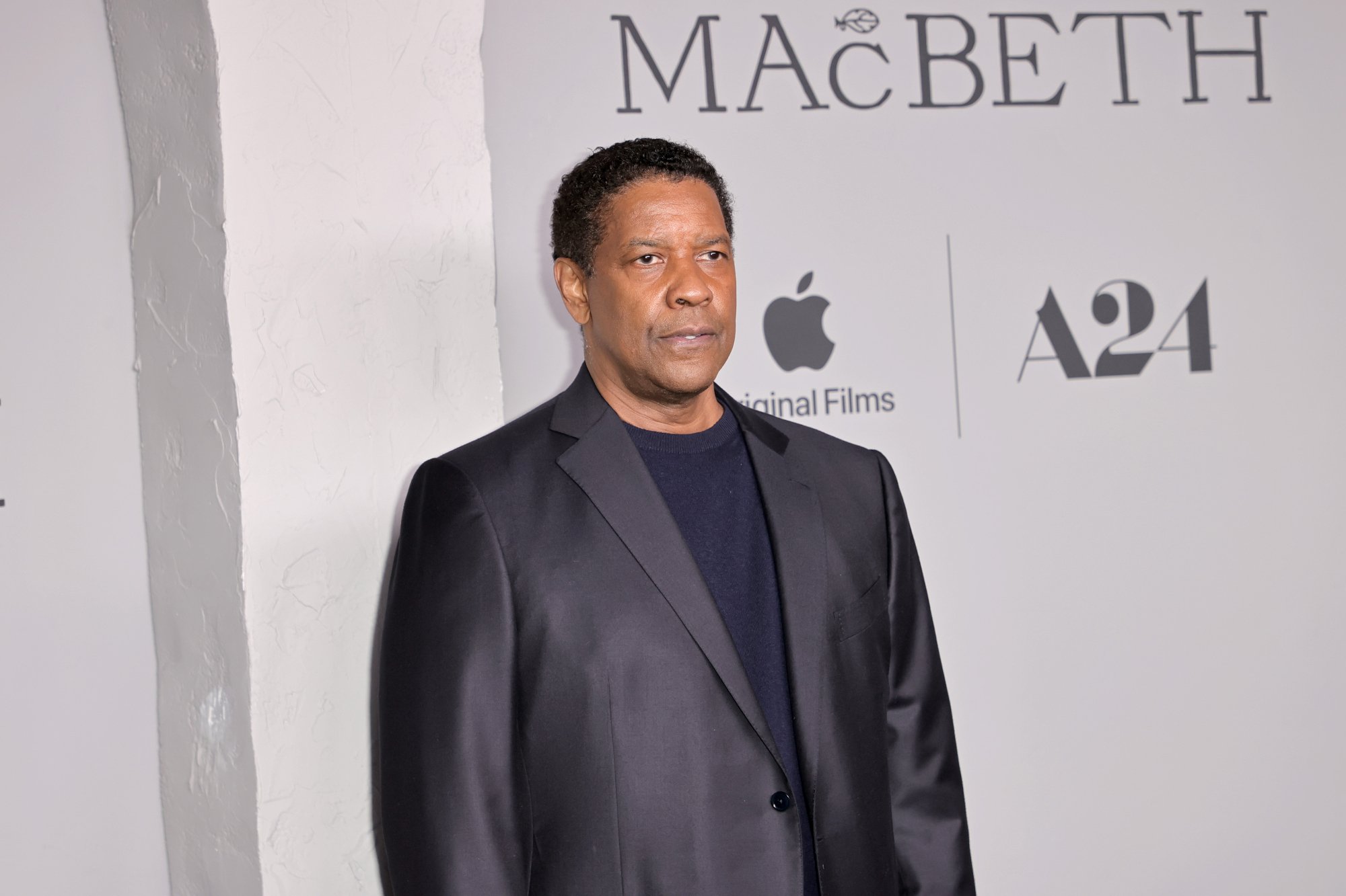'The Tragedy of Macbeth' actor Denzel Washington standing in front of white step and repeat
