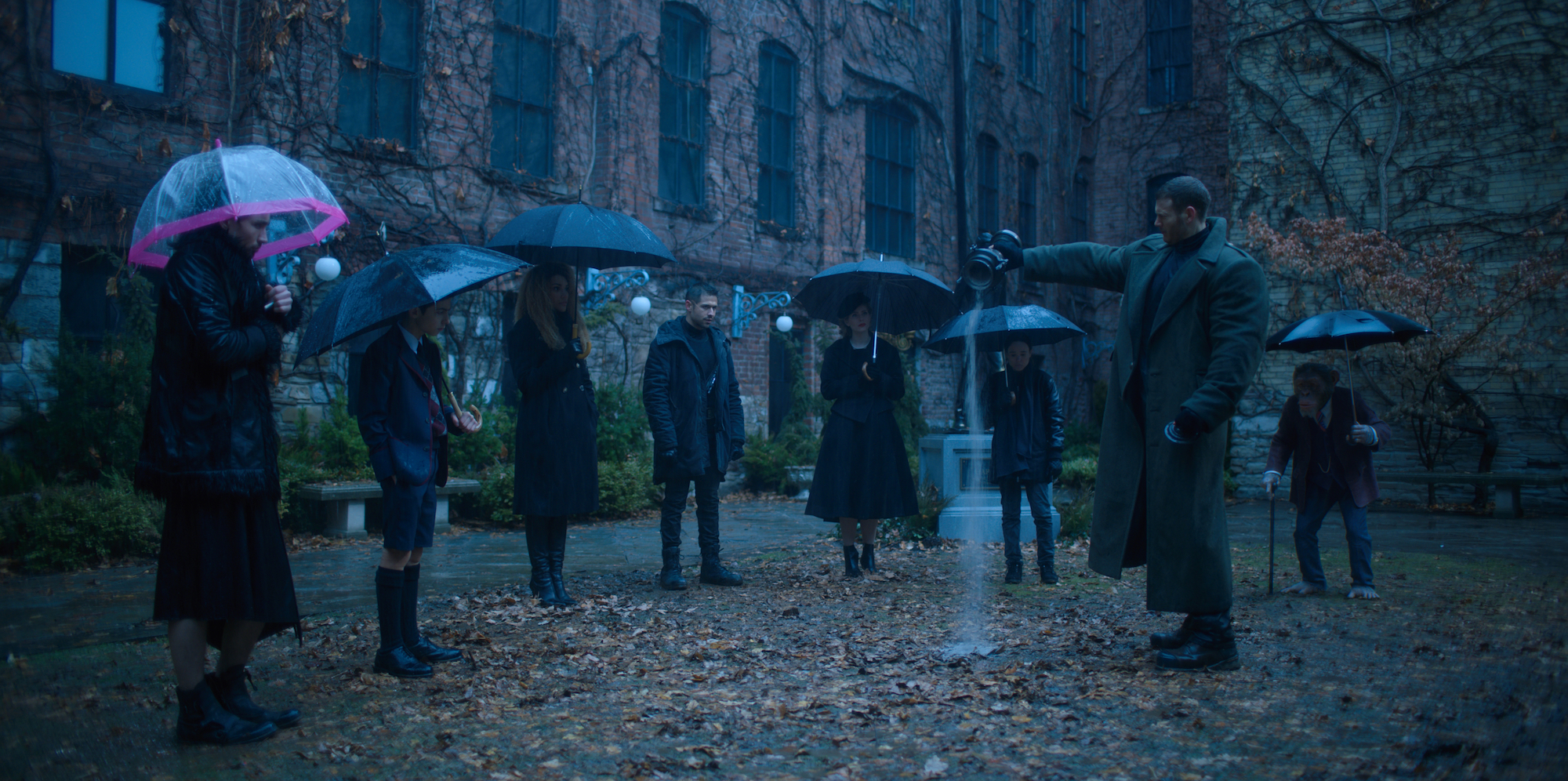 Members of The Umbrella Academy gather for their father's funeral in a production still from 'The Umbrella Academy' Season 1.