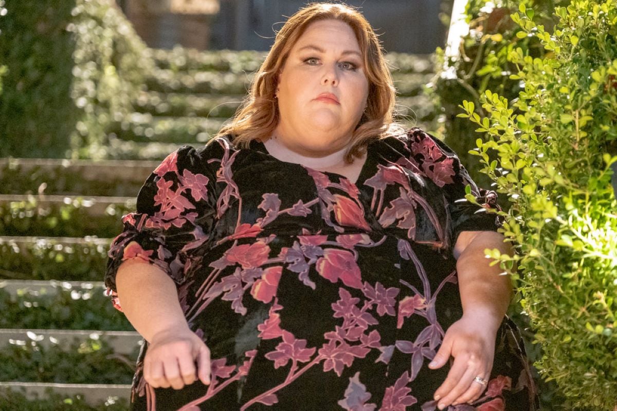 'This Is Us' Season 6 Episode 9 star Chrissy Metz, in character as Kate Pearson, wears a black dress with pink and red flowers on it.