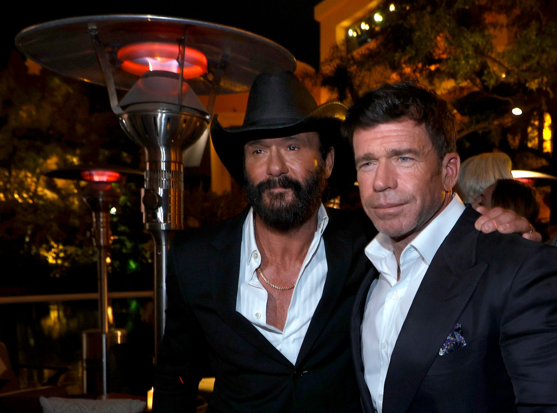Tim McGraw from the '1883' cast with his arm around show creator Taylor Sheridan at an event