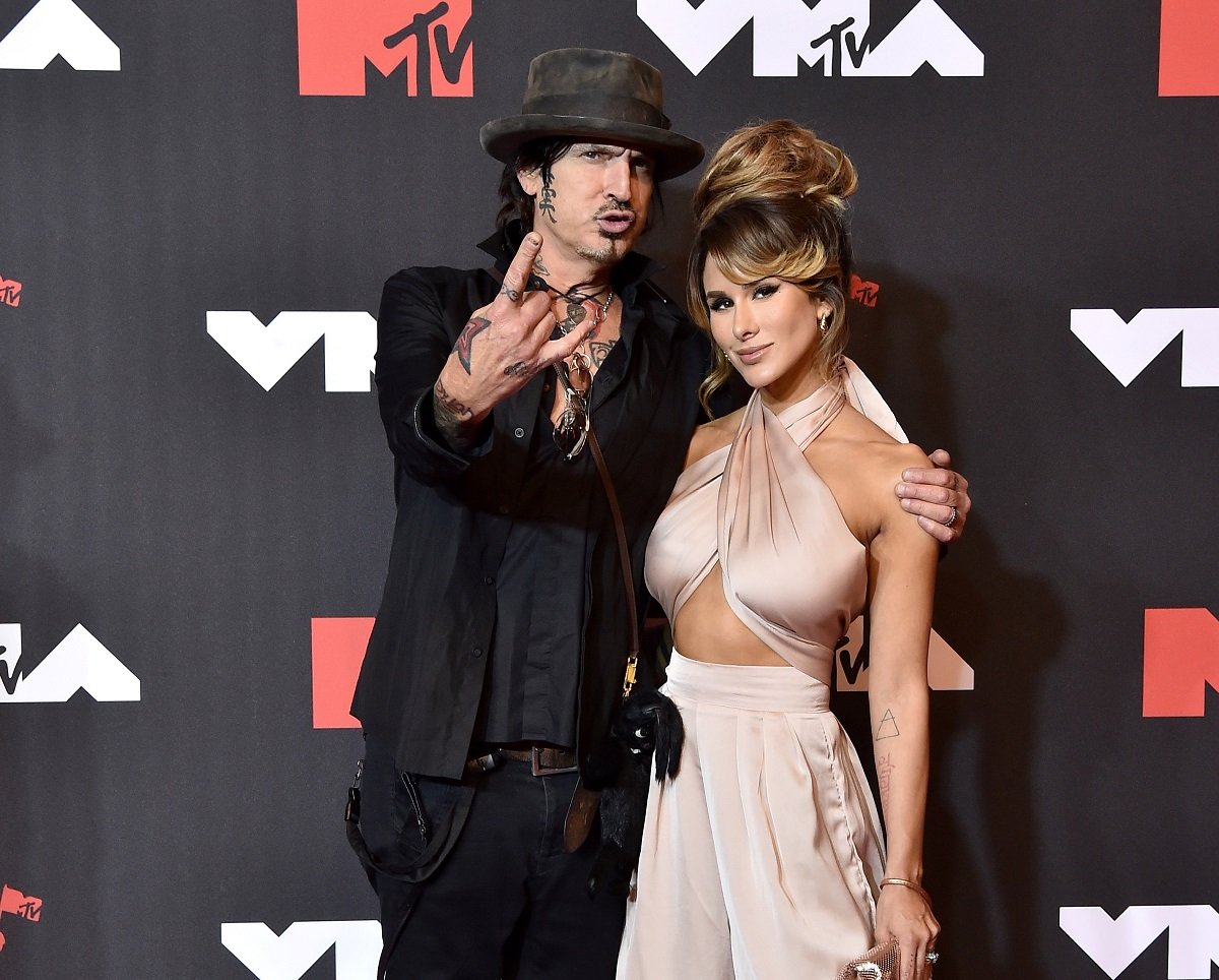 Tommy Lee posing on the red carpet with his wife Brittany Furlan who he shares a Calabasas mansion with