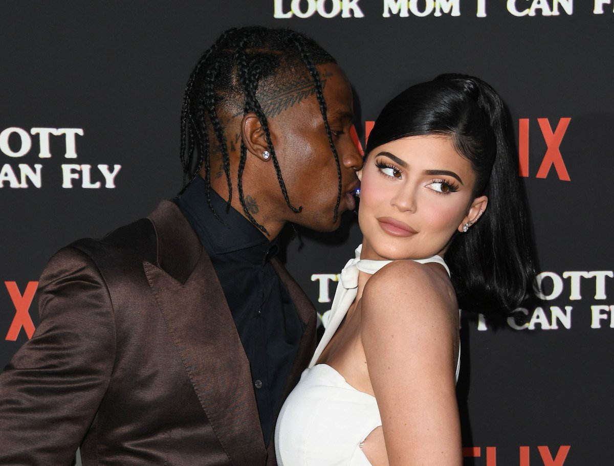 Travis Scott kisses Kylie Jenner at an event.