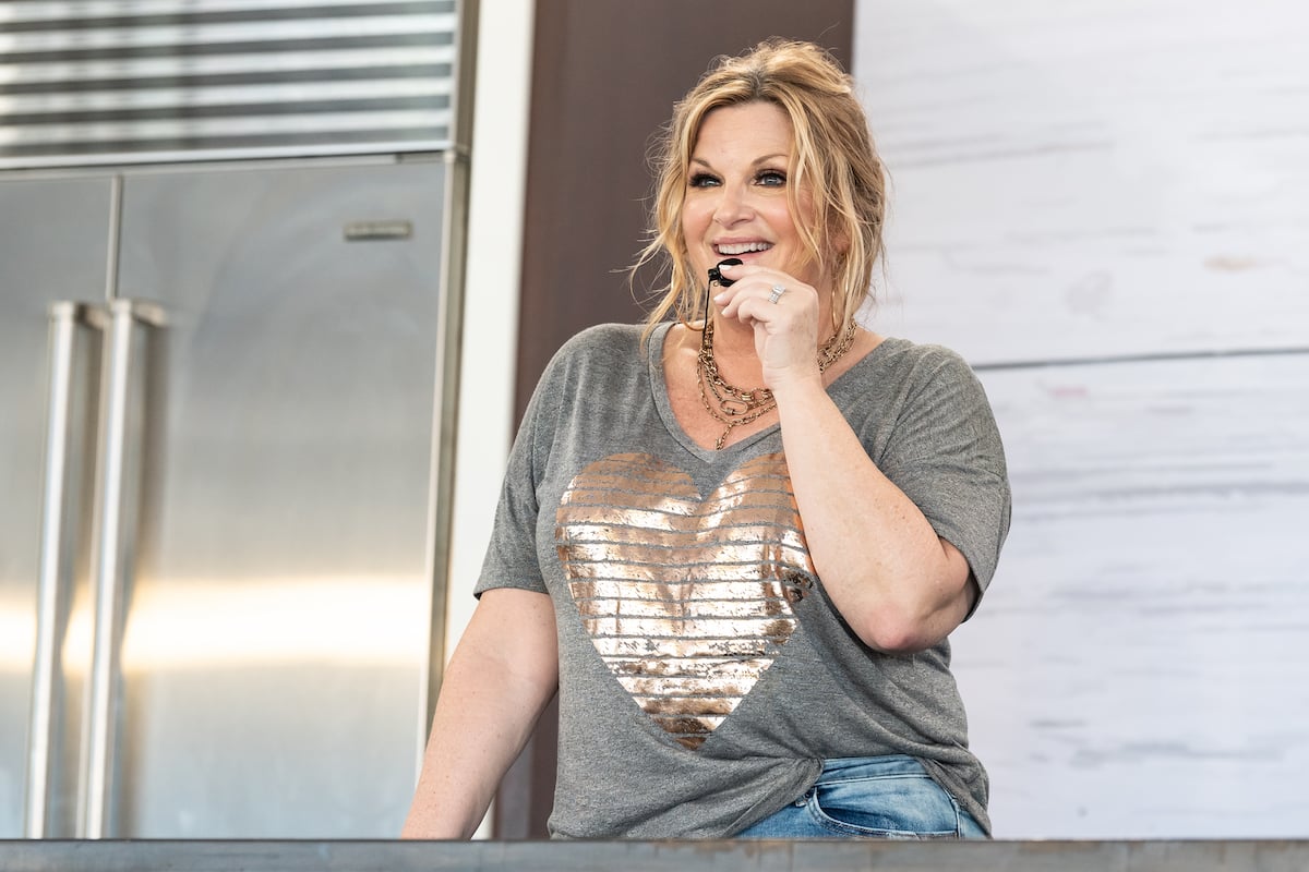 'Trisha's Southern Kitchen' host Trisha Yearwood speak into a mic wearing a gray t-shirt at the 2022 South Beach Wine and Food Festival
