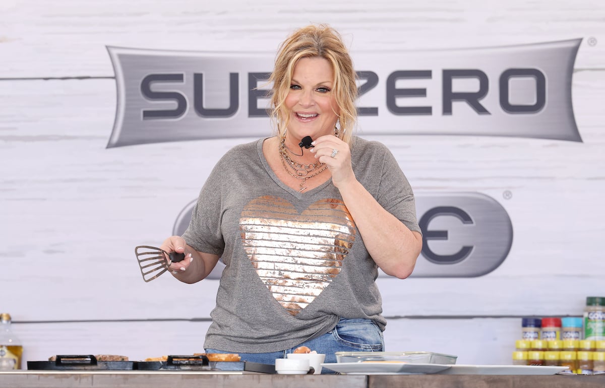 Trisha Yearwood cooks wearing a gray shirt at the 2022 South Beach Wine and Food Festival