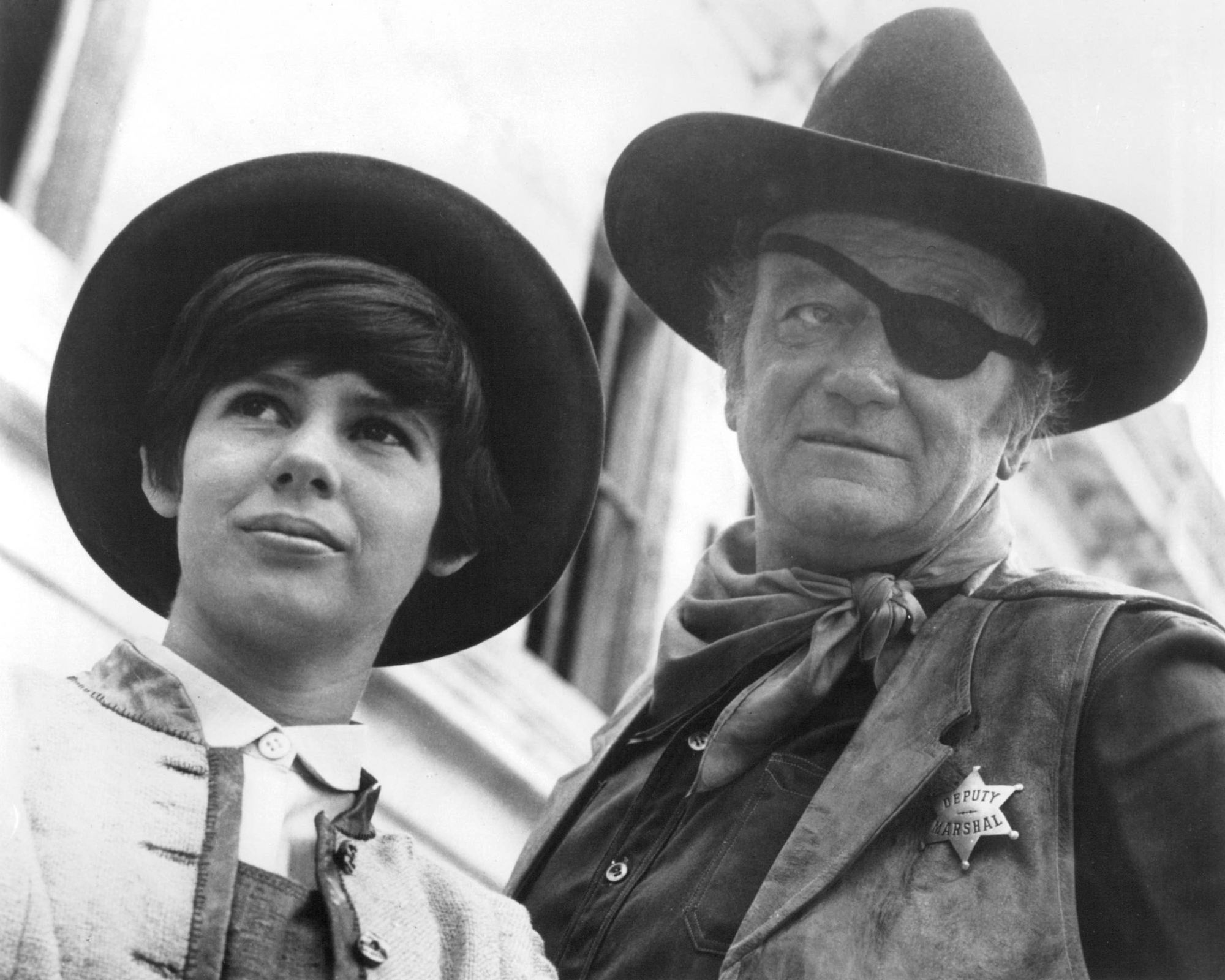 'True Grit' Kim Darby as Mattie Ross and Oscar-winner John Wayne as Rooster Cogburn wearing cowboy hats and Western clothing in black-and-white