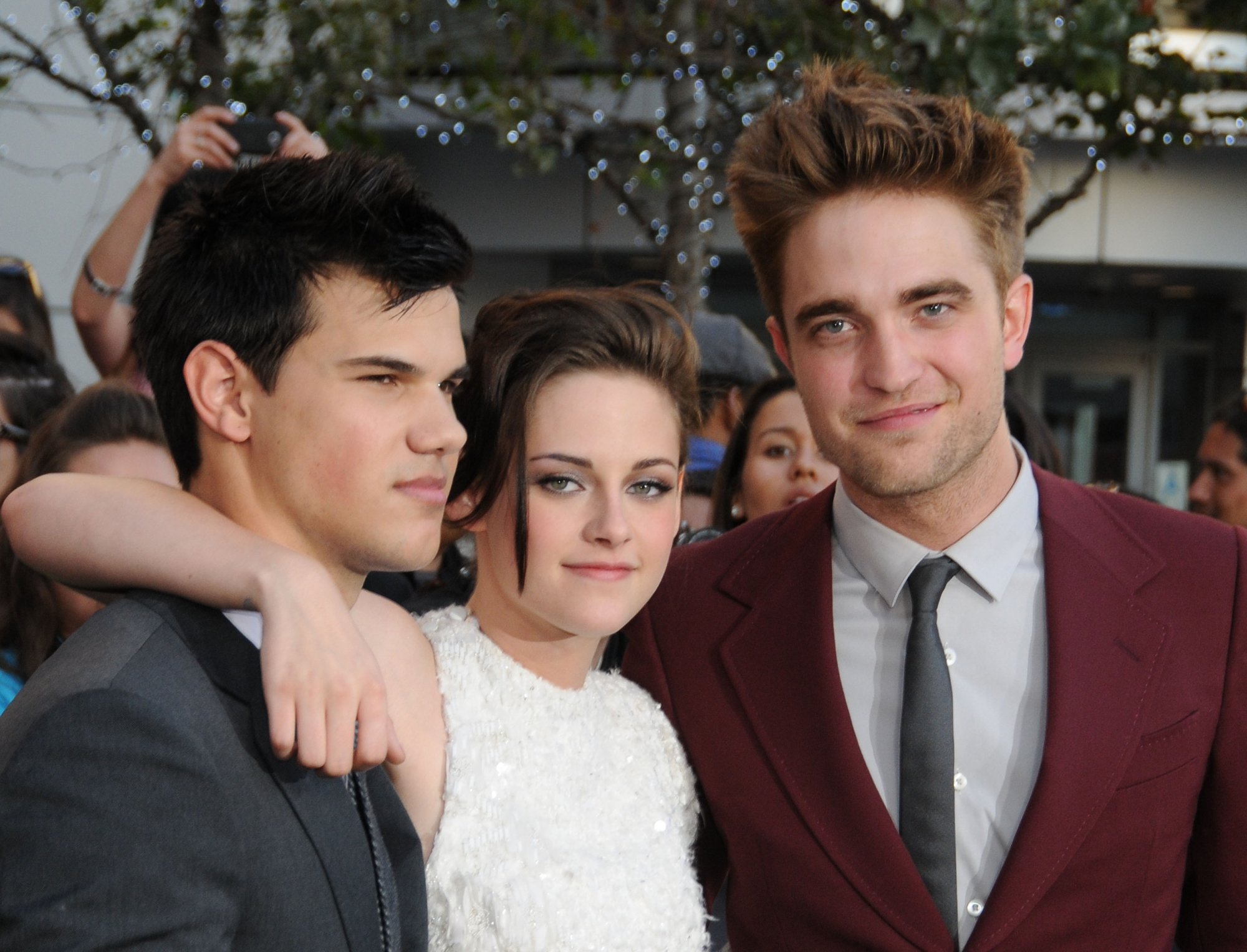 'Twilight' Taylor Lautner, Robert Pattinson, and Kristen Stewart, who plays Bella in the Swan home in formal clothes with people taking pictures in the background