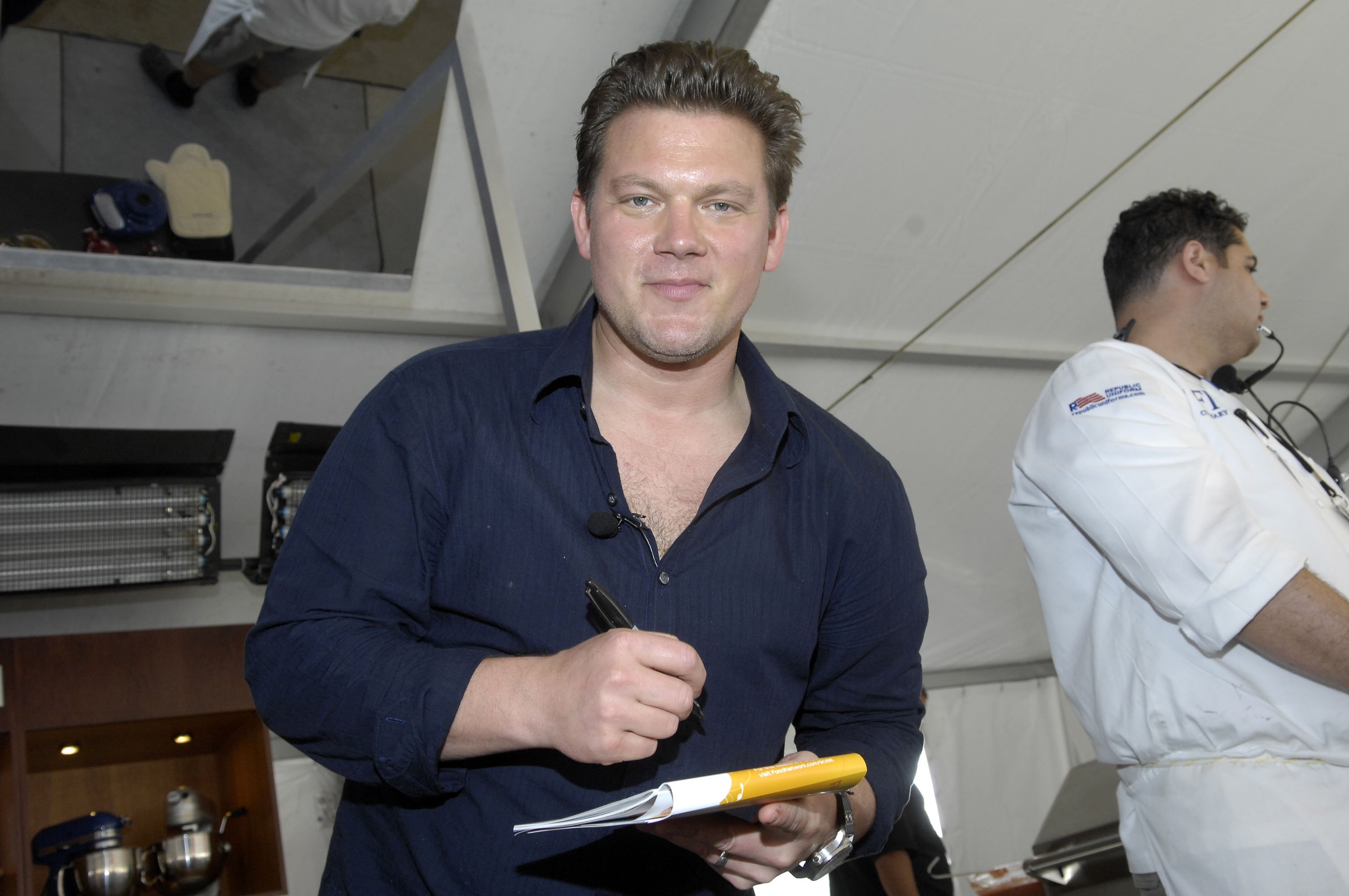 Food Network personality Tyler Florence wears a dark blue button-down shirt in this photograph.