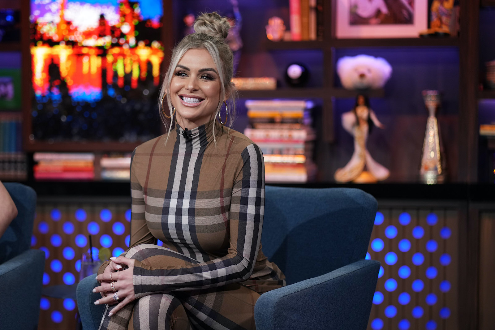 Lala Kent from 'Vanderpump Rules' smiles while sitting in a chair at 'WWHL'