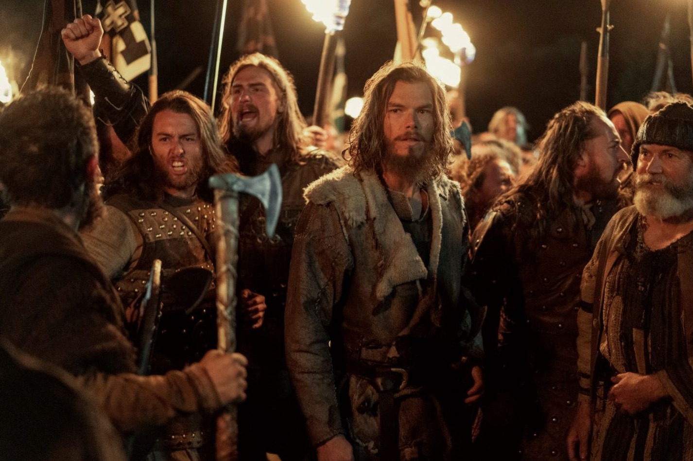 Sam Corlett wears full Viking clothes and stands with fellow Vikings in "Vikings: Valhalla".