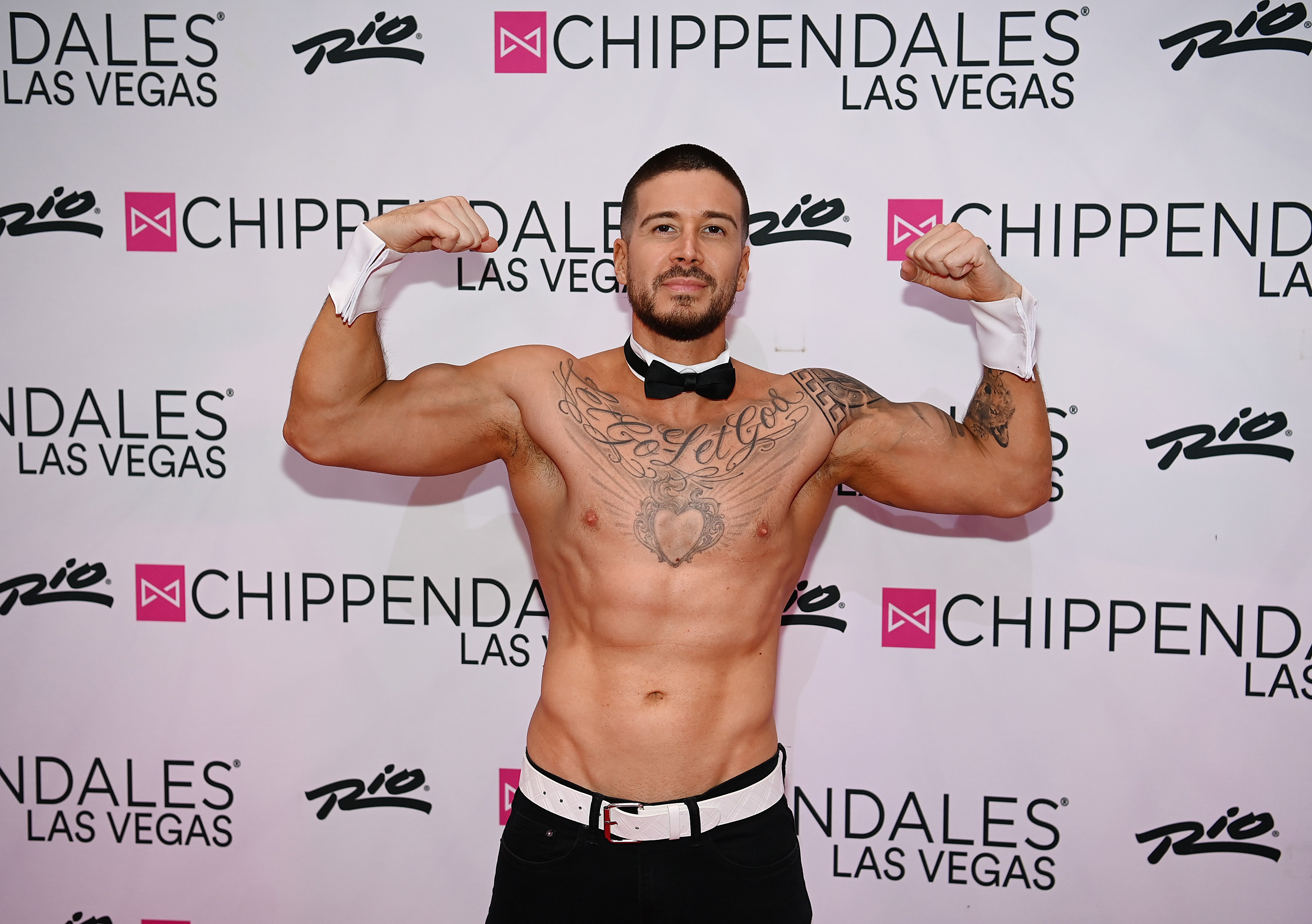 Vinny Guadagnino poses in front of a step-and-repeat for Chippendales Las Vegas