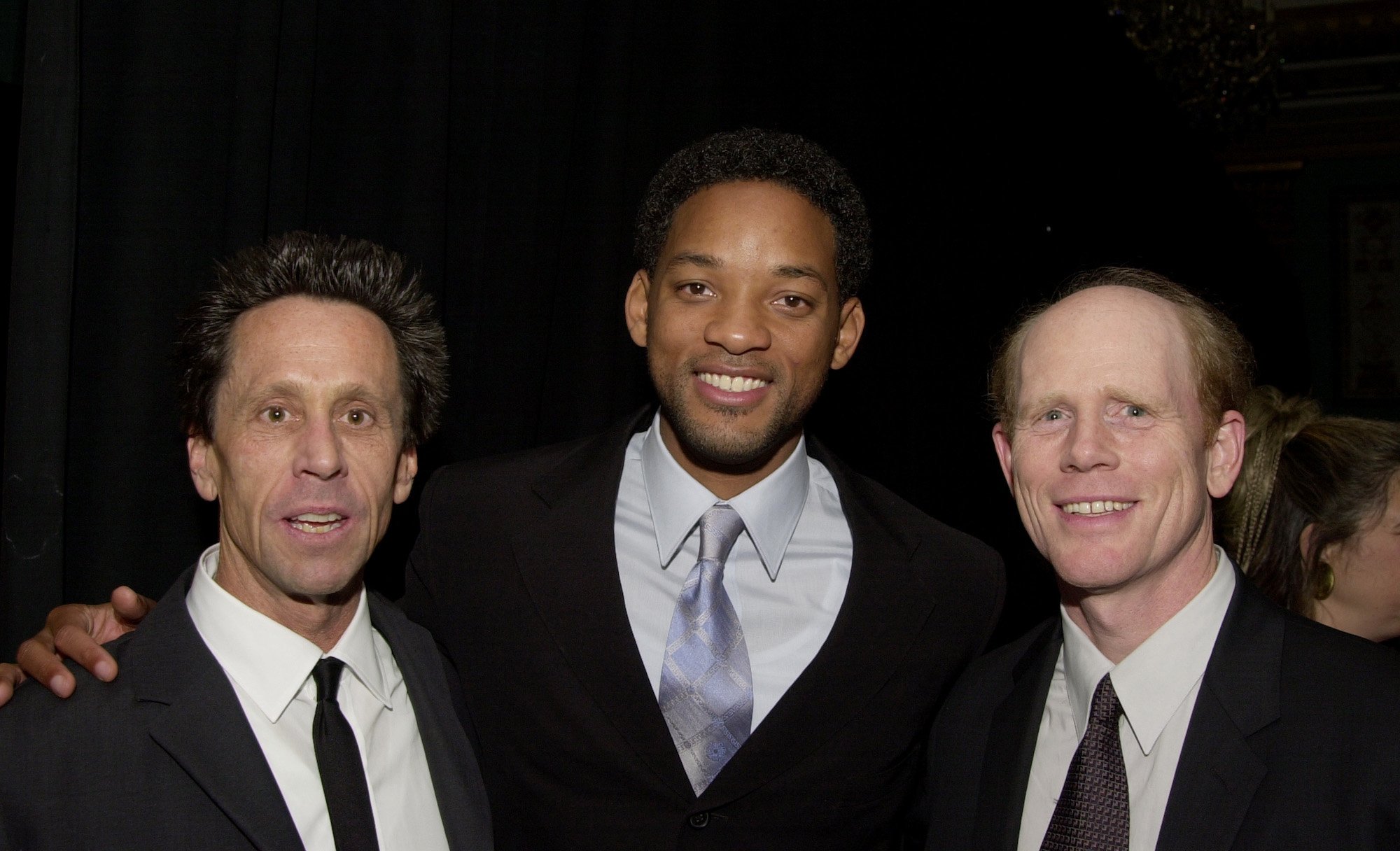 Will Smith puts his arms around Ron Howard and Brian Grazer