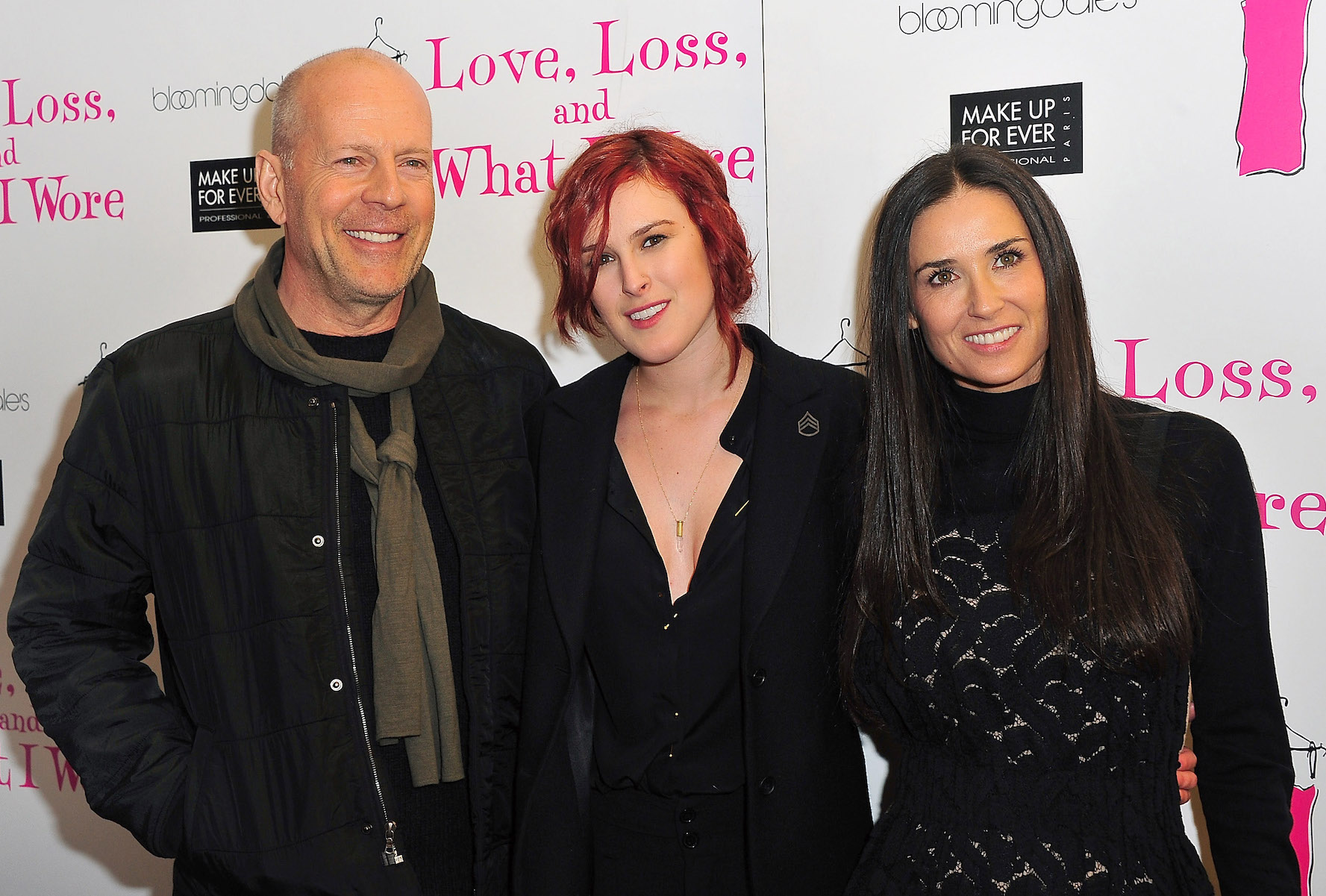 Bruce Willis, Rumer Willis, and Demi Moore standing together and smiling at an event