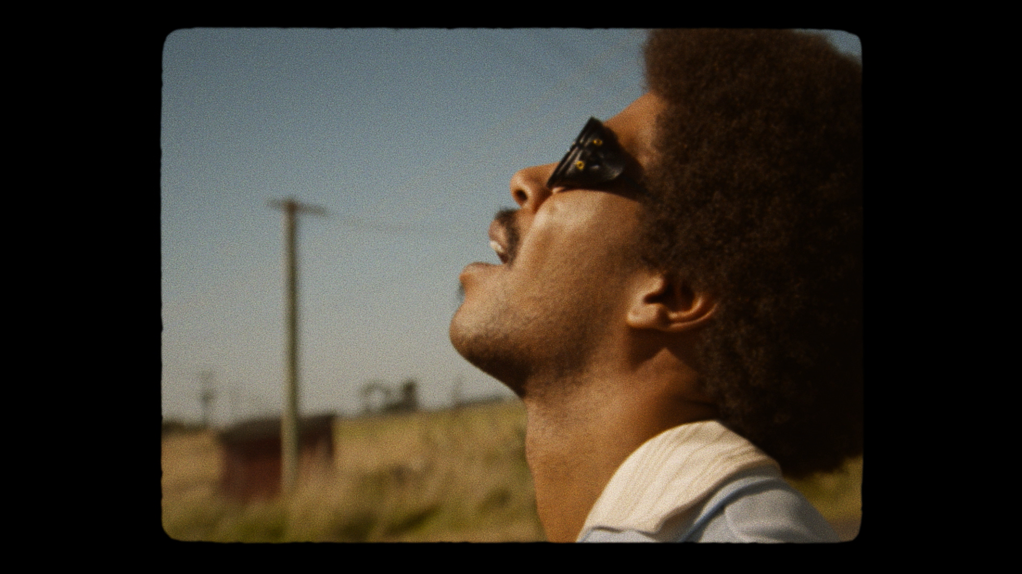 'X' Scott Mescudi as Jackson holding his head back wearing sunglasses