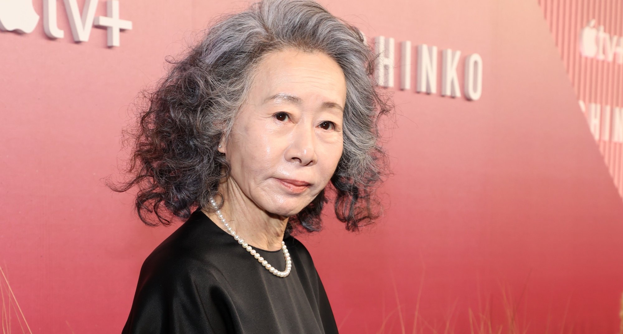 Youn Yuh-jung for 'Pachinko' series wearing black dress and pearls.