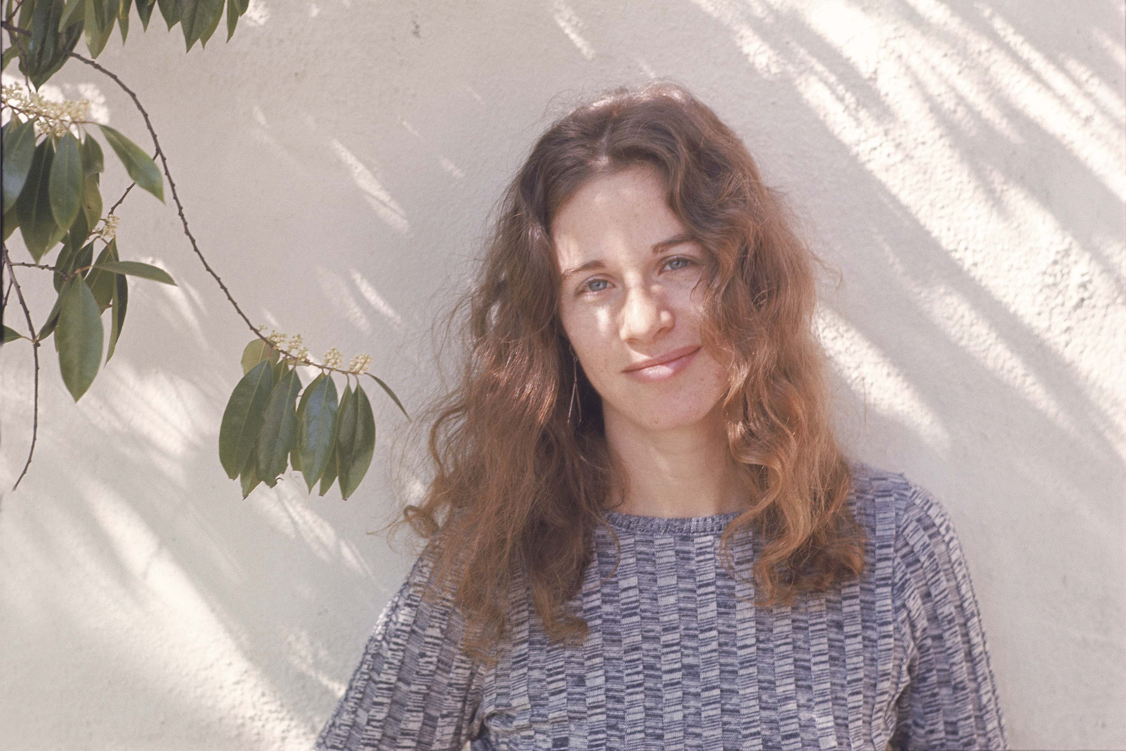 Carole King near a plant