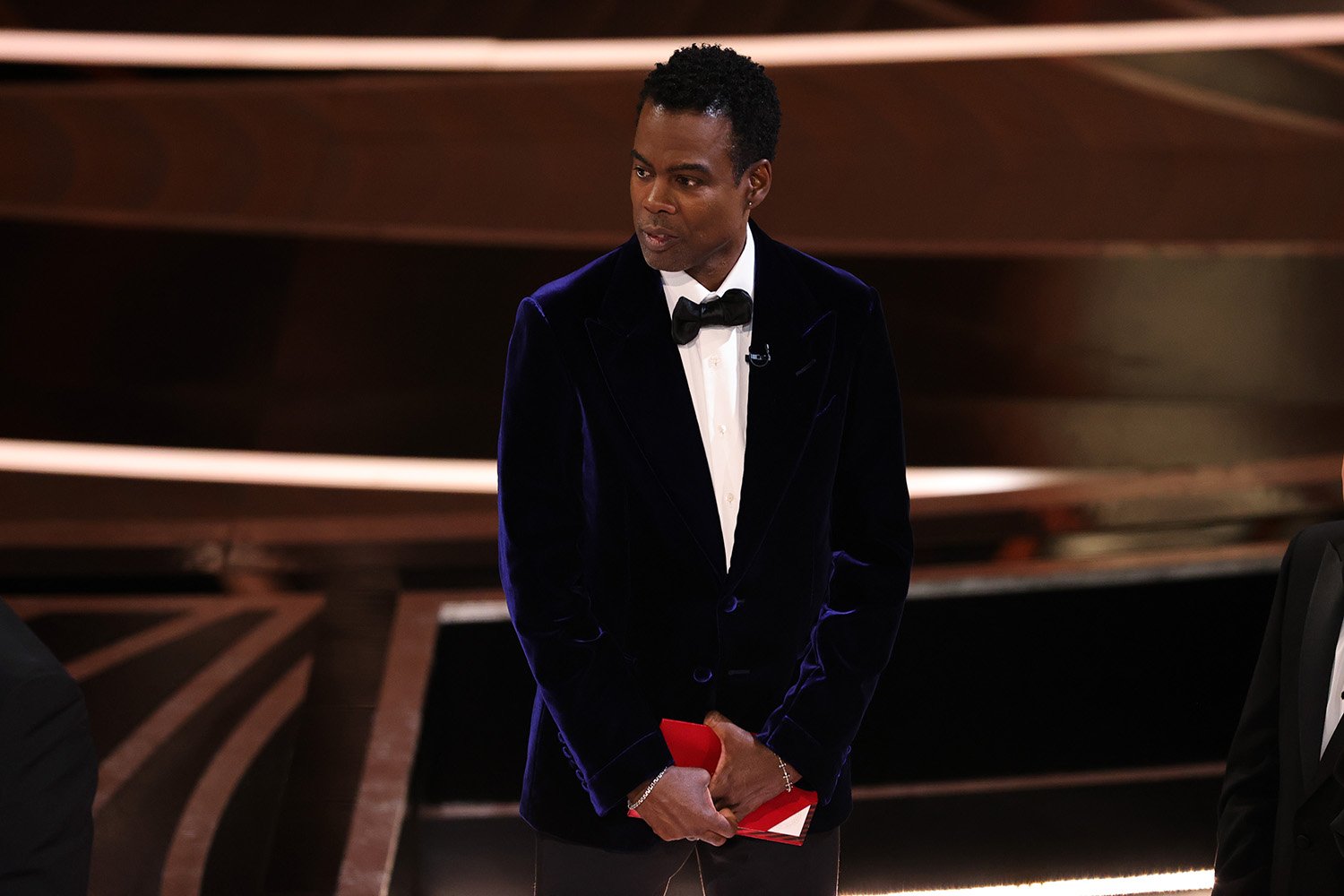 Chris Rock onstage at Oscars 2022 moments after the Will Smith slap. Chris Rock is not pressing charges against Will Smith.