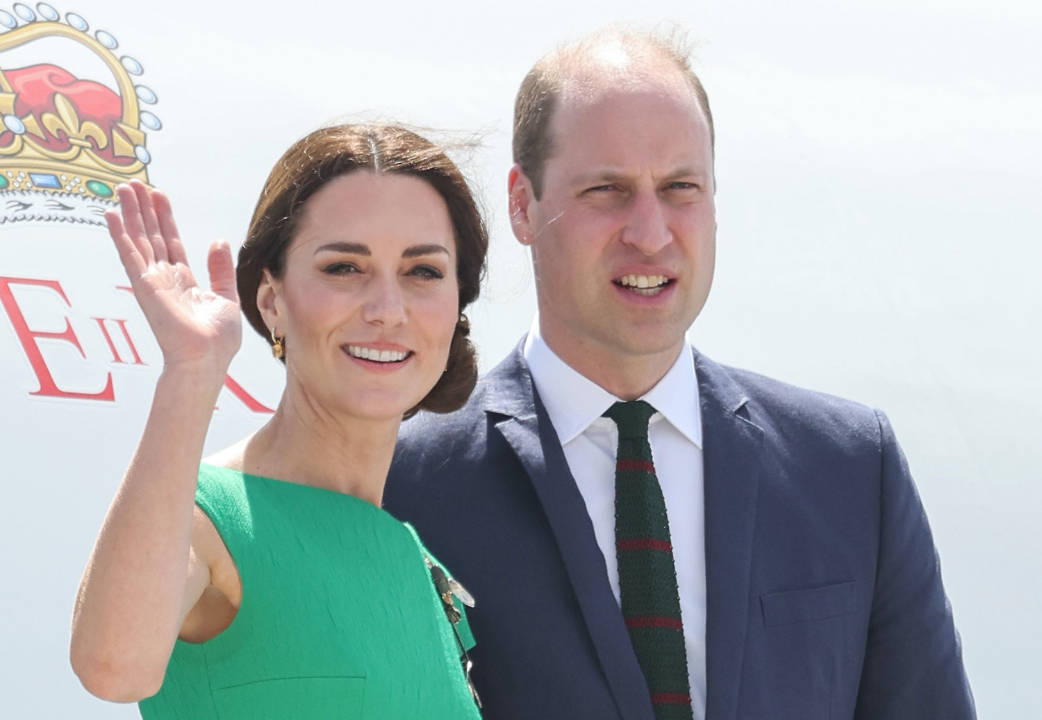 Kate Middleton wears a green dress as she smiles and waves while Prince William looks on