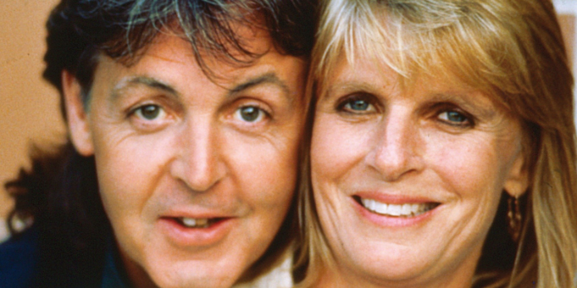 Paul and Linda McCartney pose with their heads together in a color photograph.